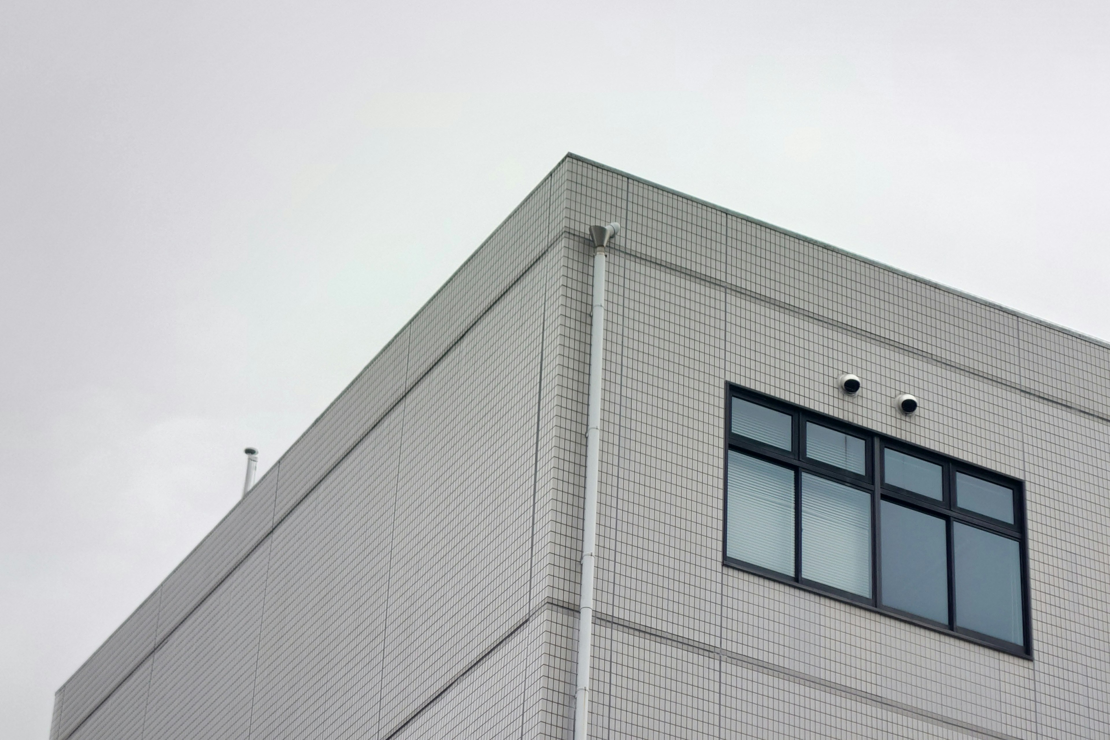 Image montrant le coin d'un bâtiment blanc avec des fenêtres