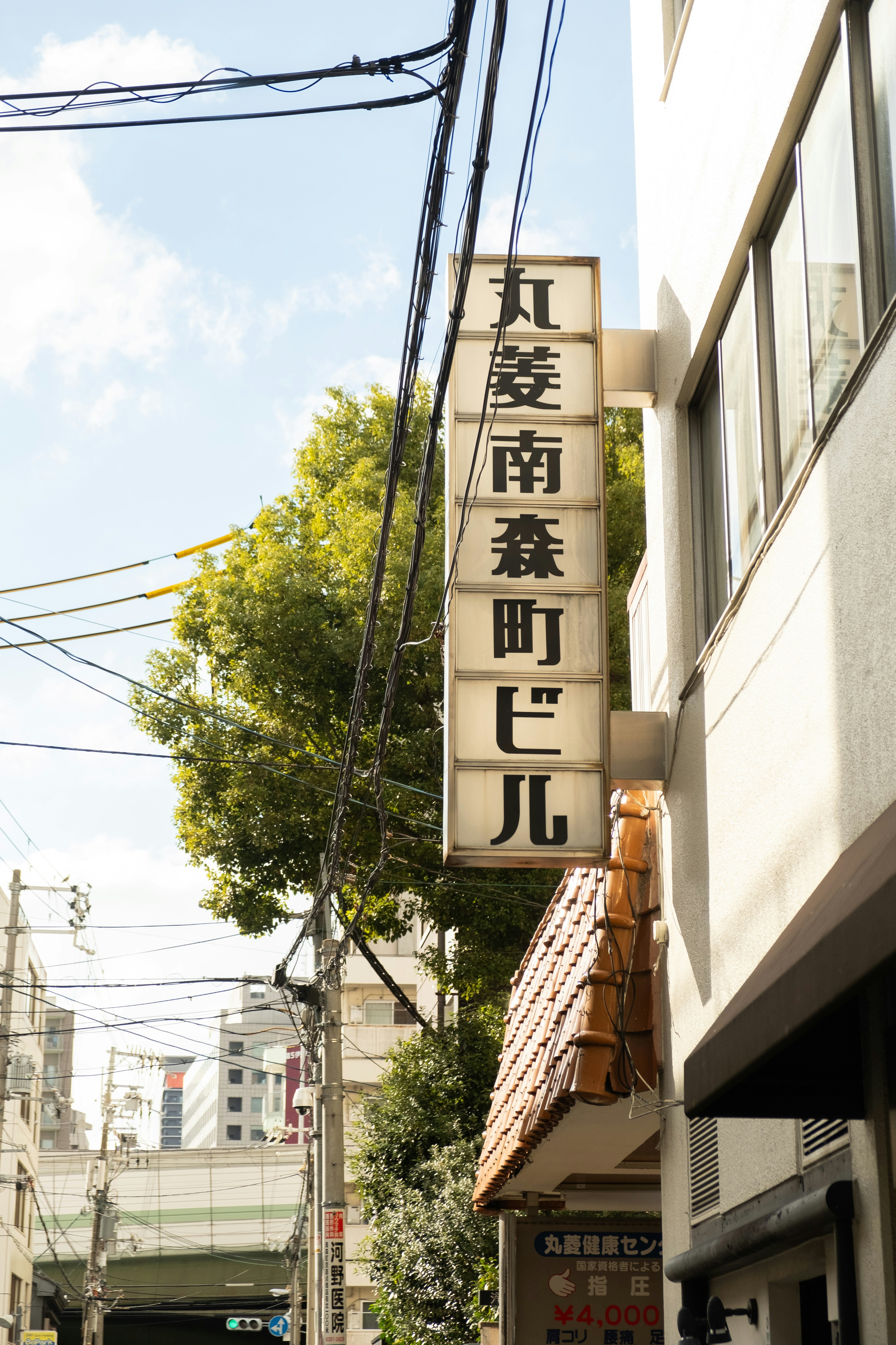 青空と木々の背景にある古い日本の看板