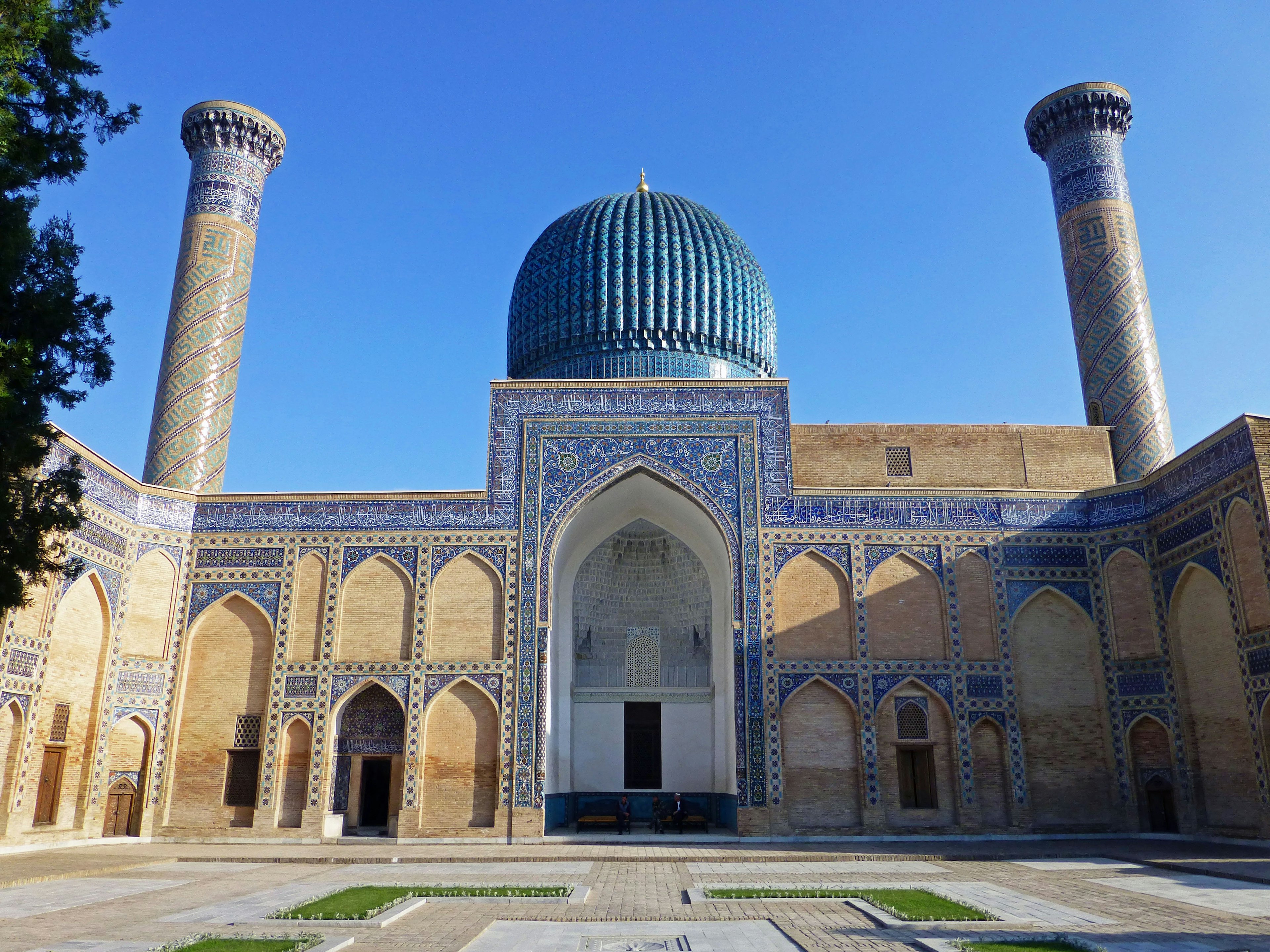 Fassade eines großen Gebäudes aus der Timur-Zeit mit einer blauen Kuppel und zwei Minaretten