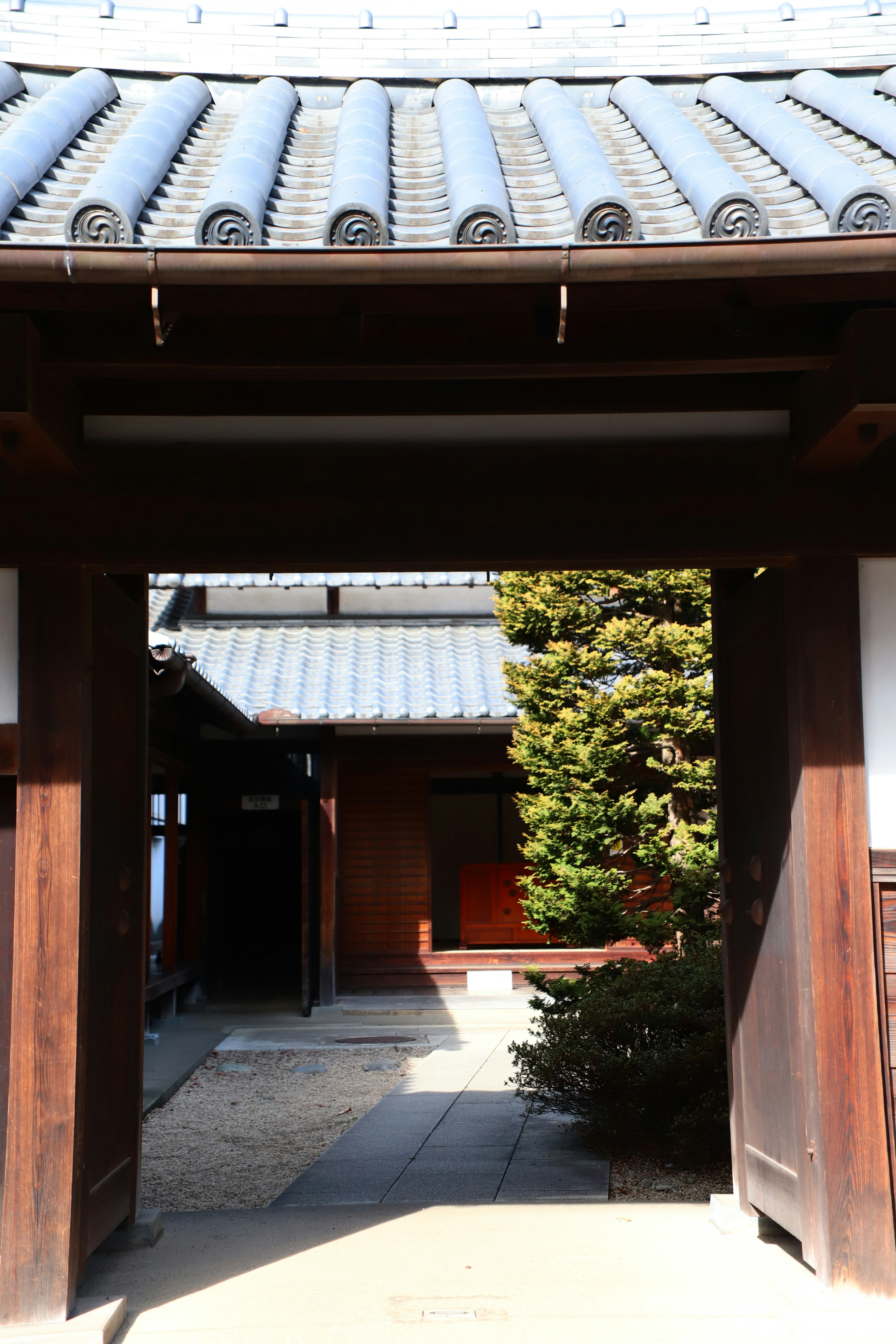 Pintu masuk bangunan Jepang tradisional dengan pemandangan taman