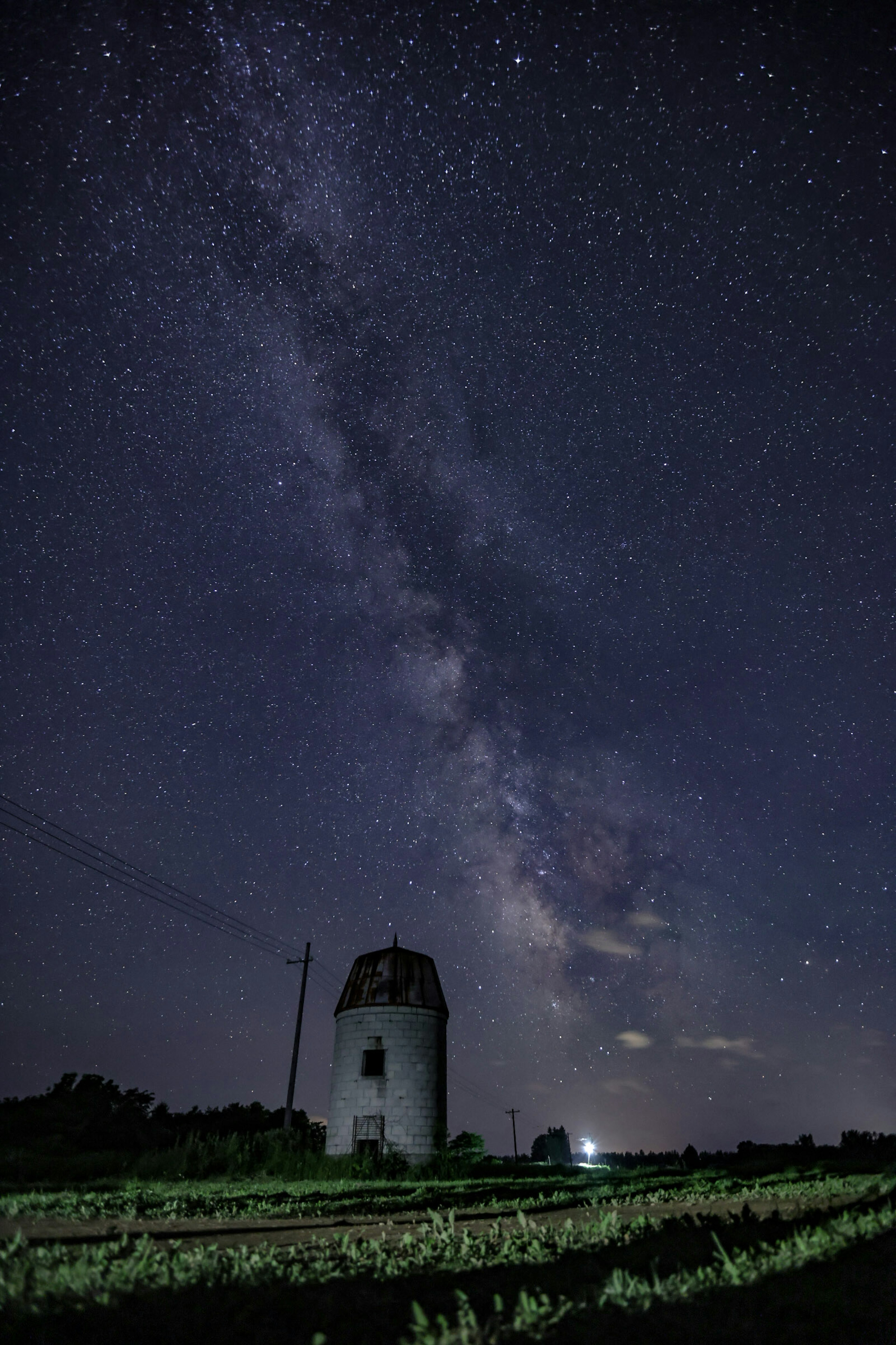 星空の下にある古い風車と天の川の美しい景色