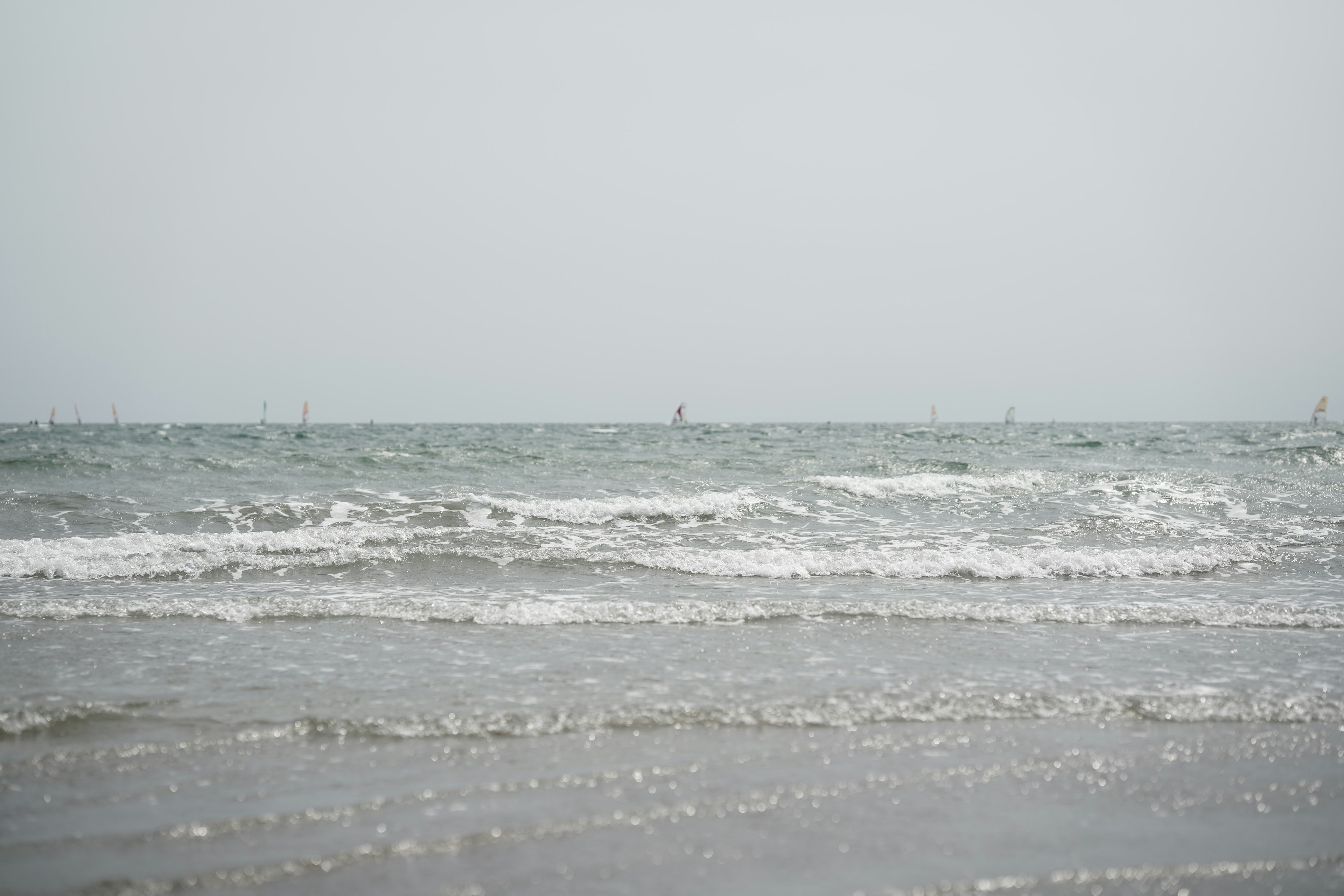 Calm seascape with waves and distant boats