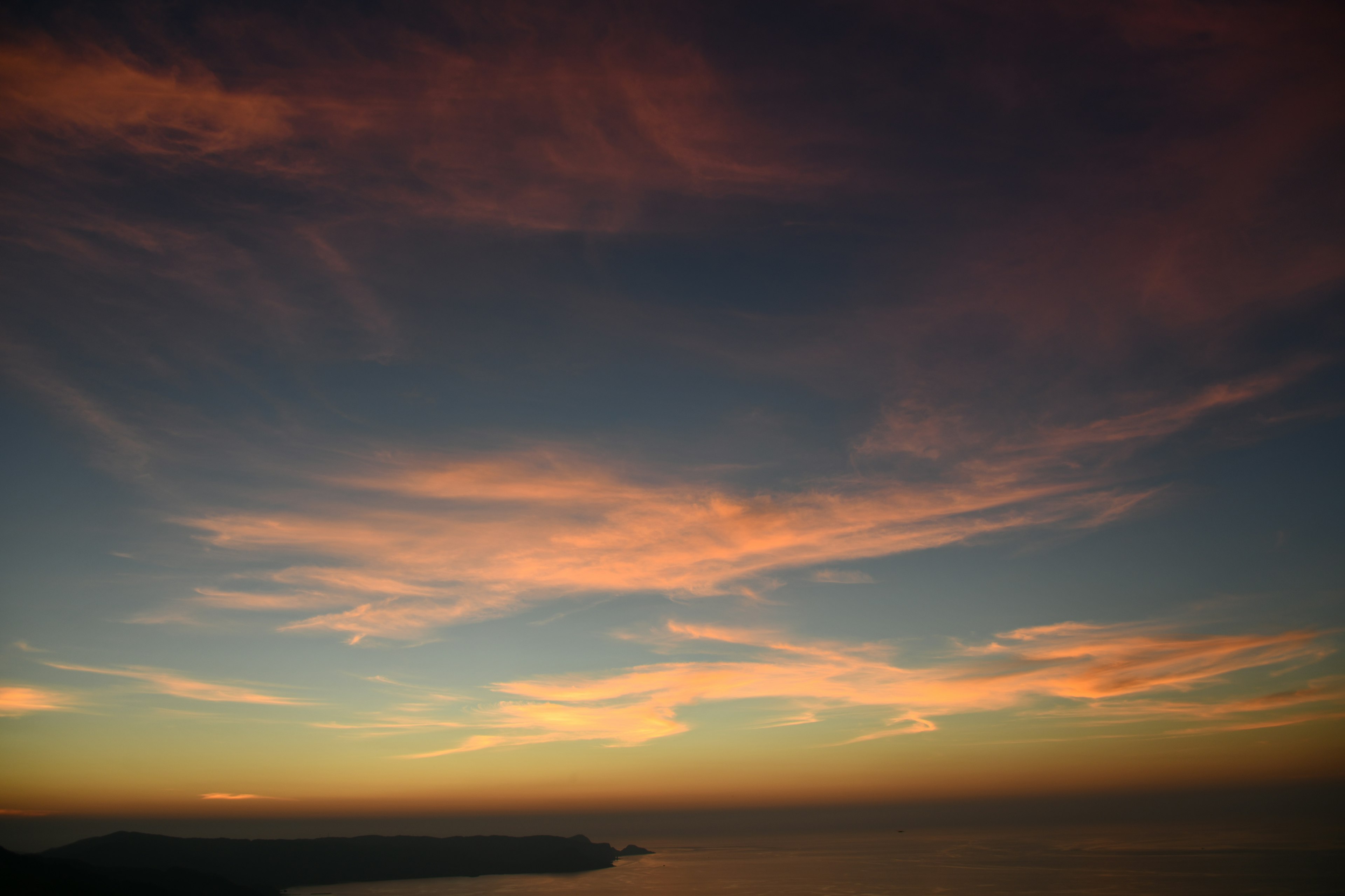 夕焼けの空と海の風景に柔らかな雲が広がる