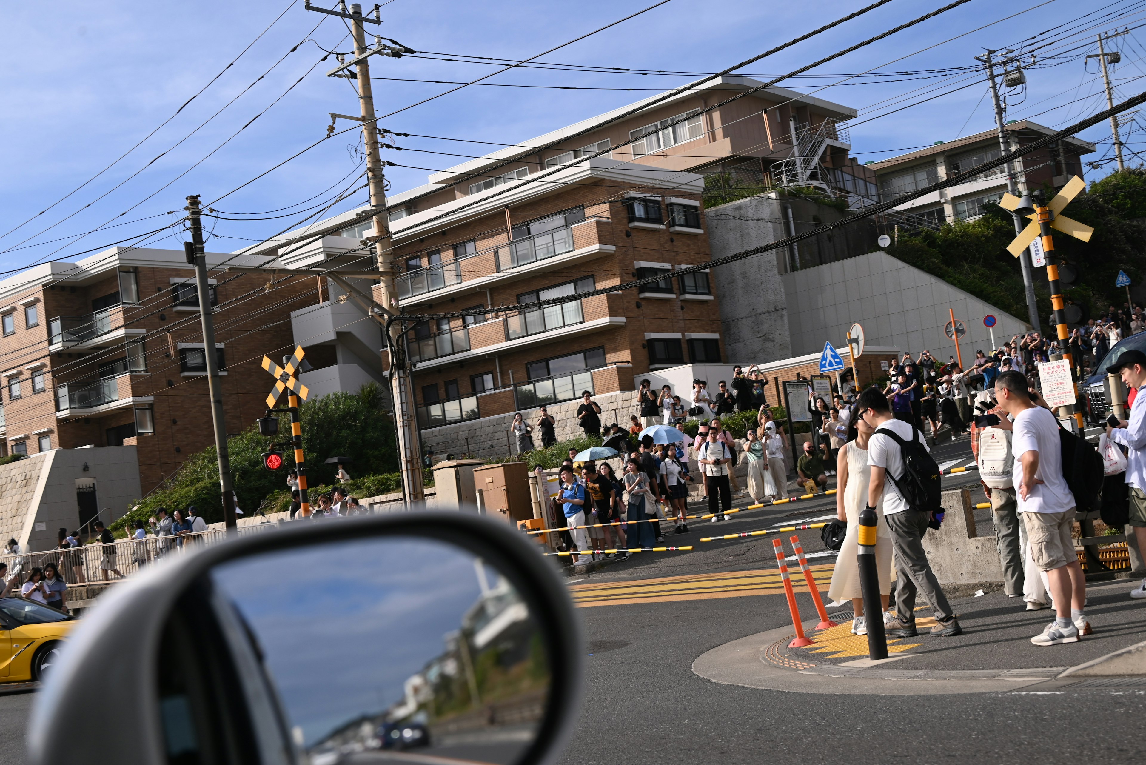 People gathering at a street intersection in a residential area with buildings