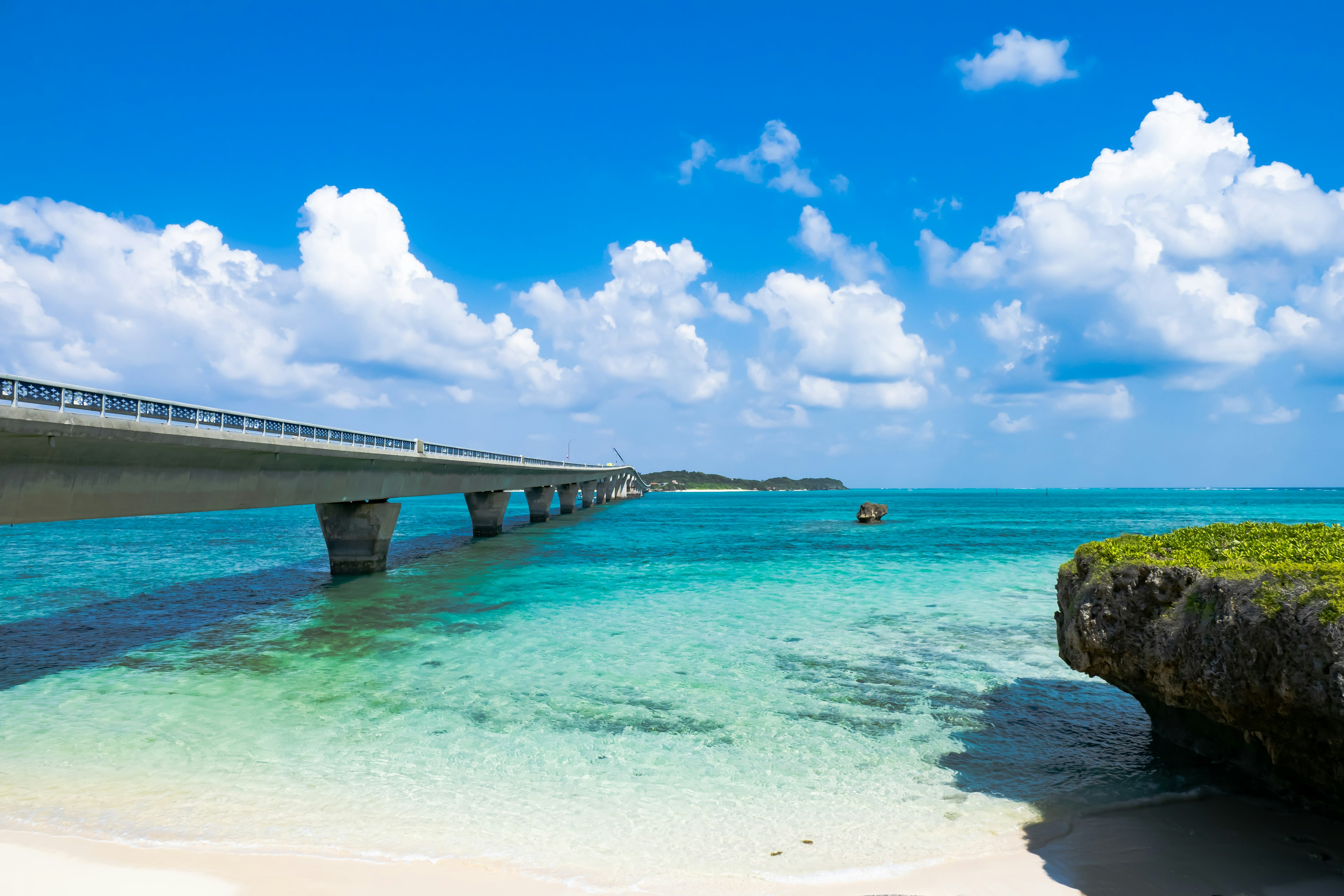 Scenic view of a blue ocean and bridge with beautiful clouds and clear water