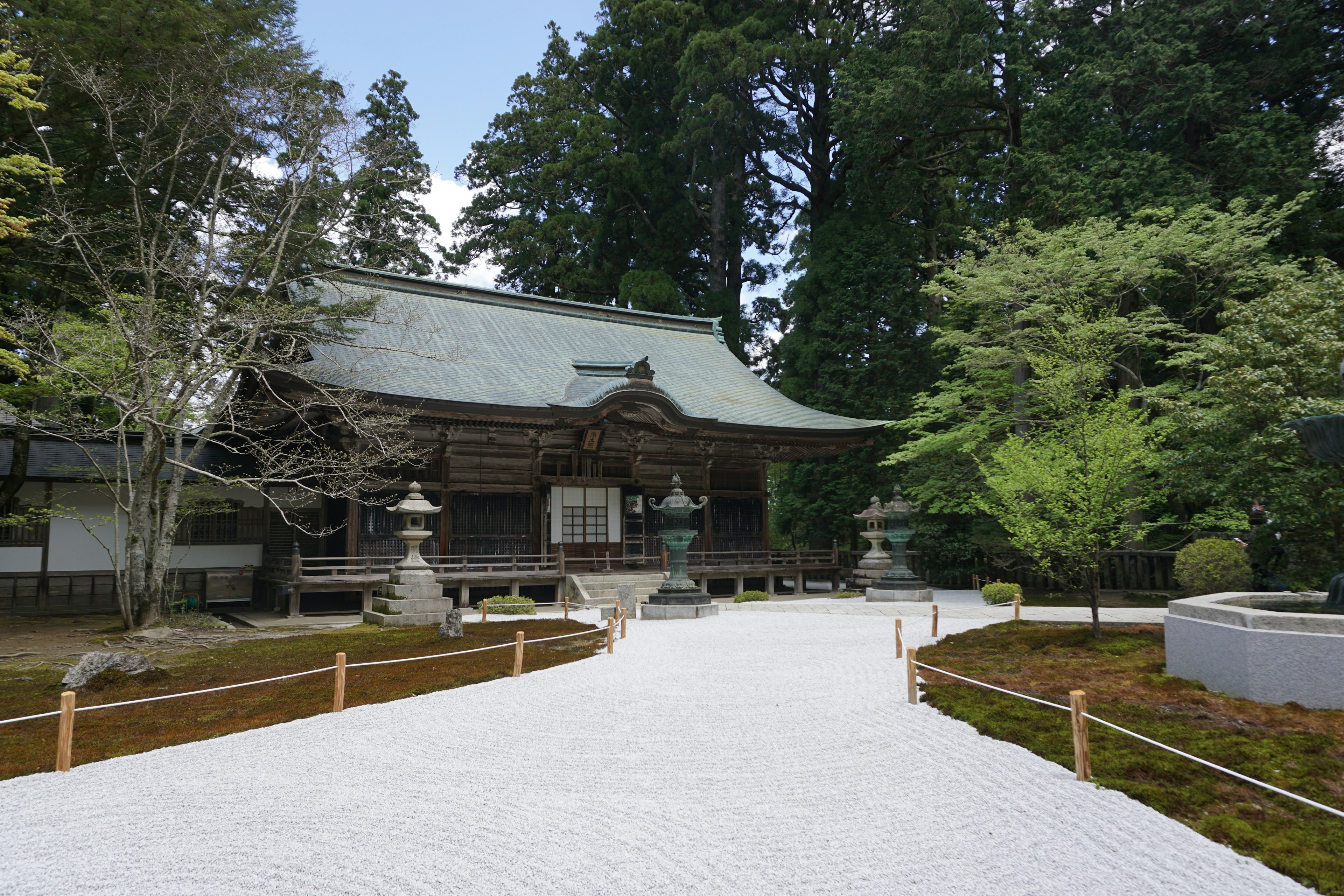 Traditional building in a serene shrine garden with lush greenery