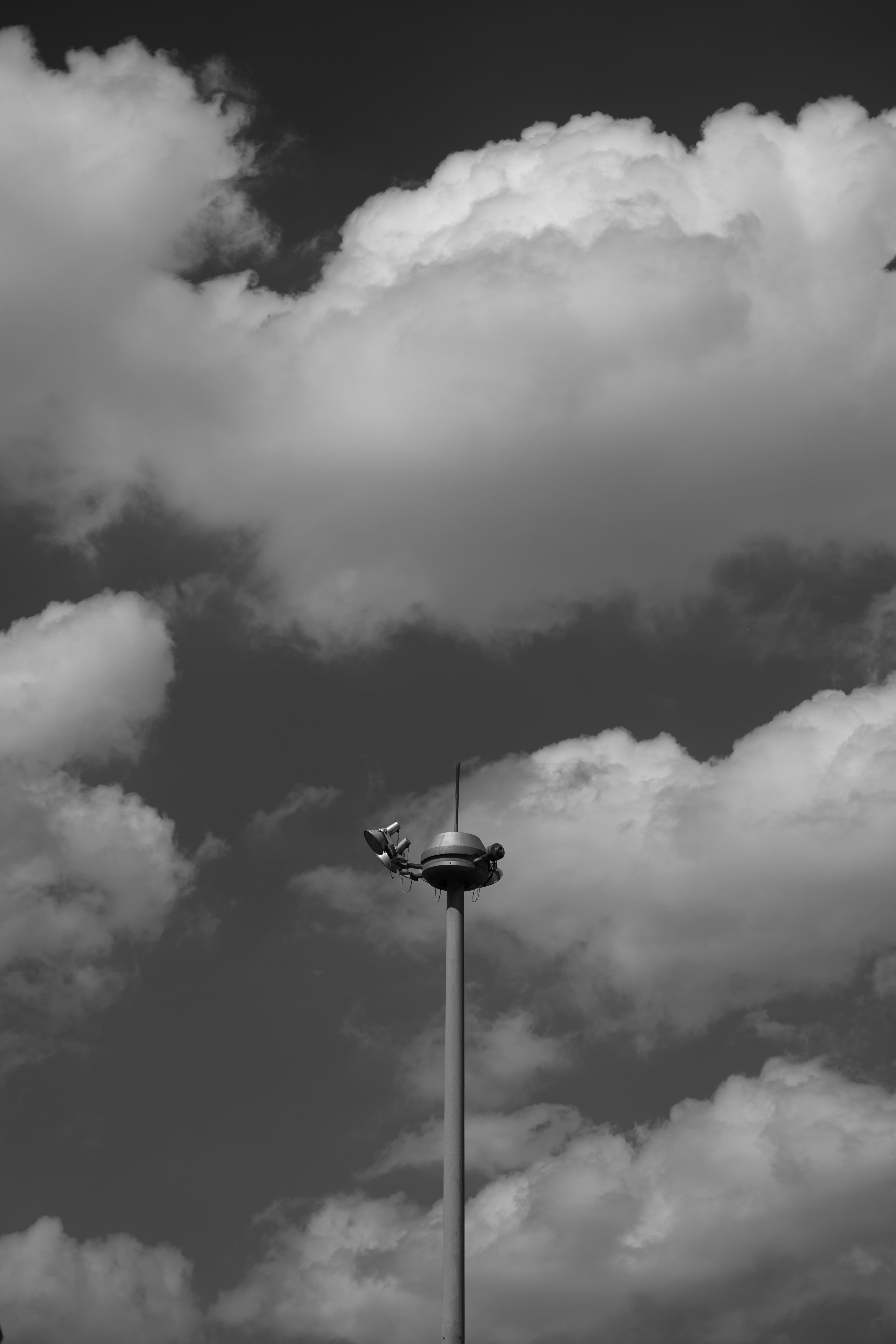 Black and white image of clouds with a streetlight