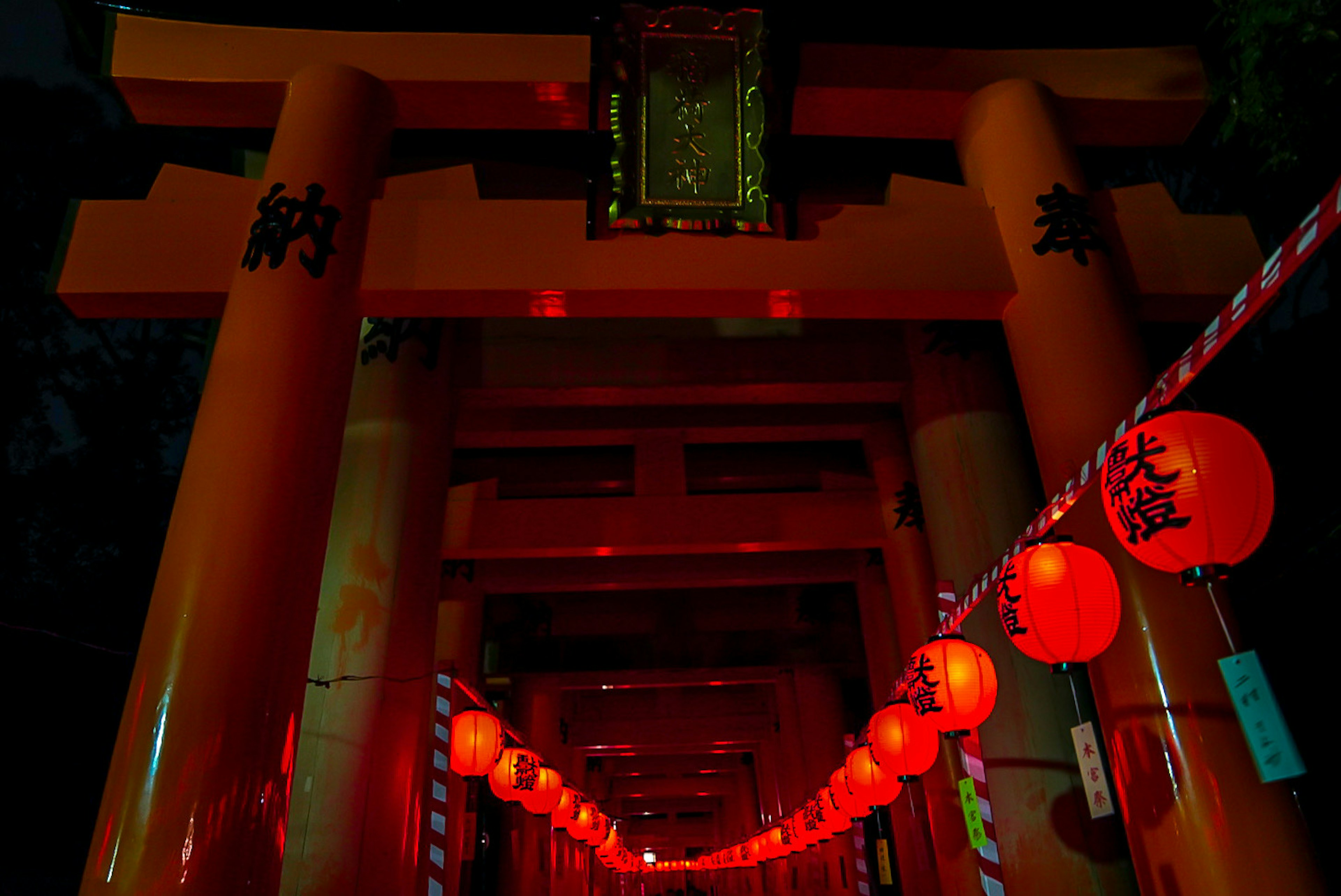 Night scene featuring red torii gate and lanterns