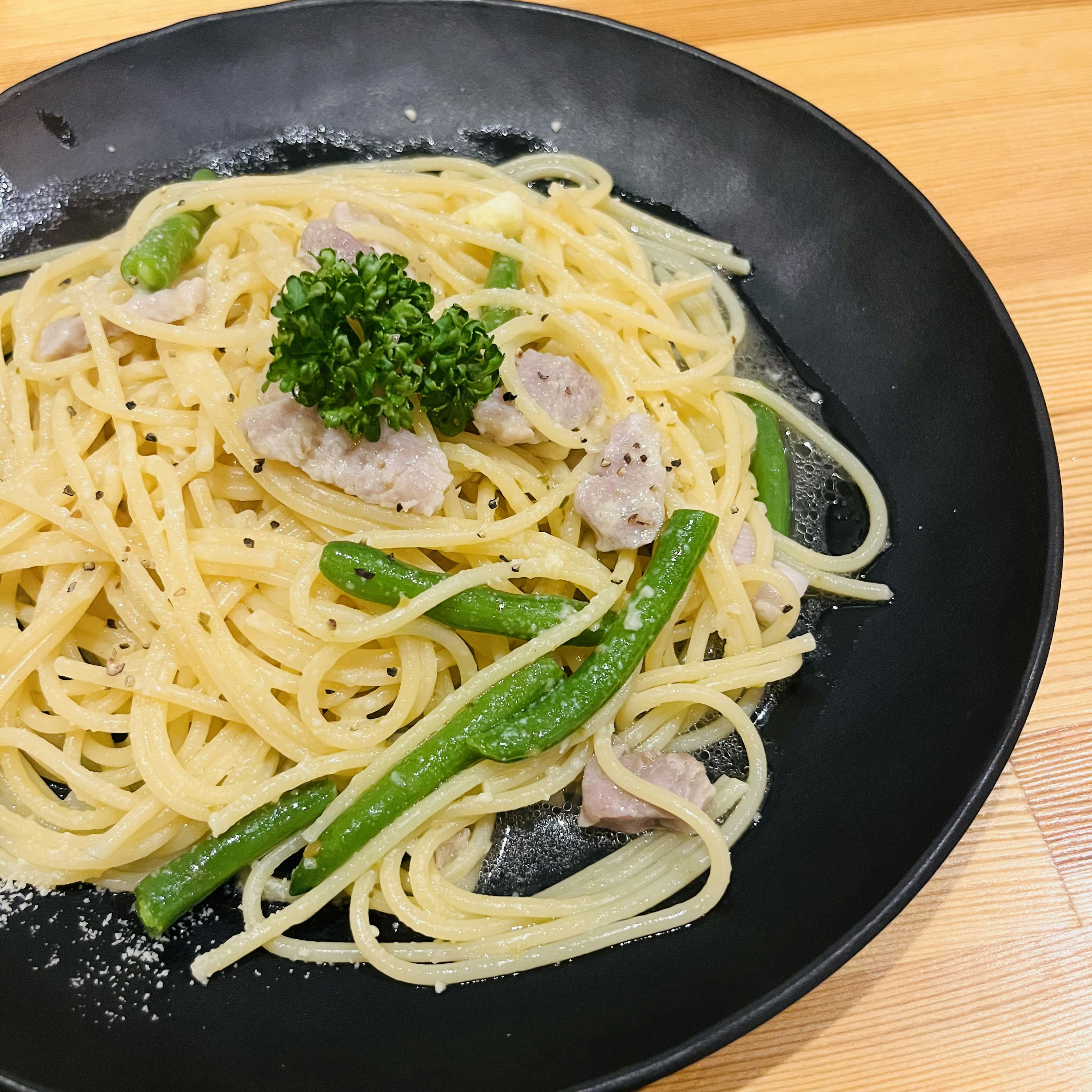 Piatto di pasta cremosa con pollo e verdure verdi guarnito con prezzemolo