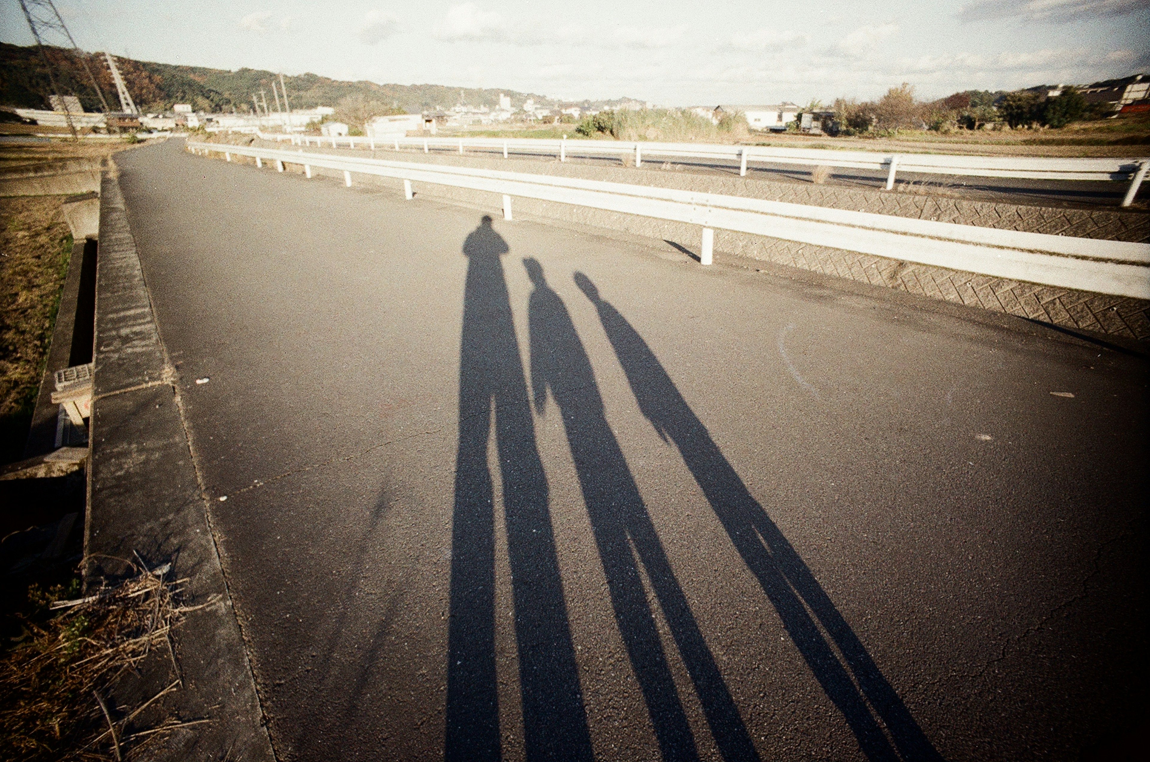 Lunghe ombre di una silhouette familiare proiettate sulla strada