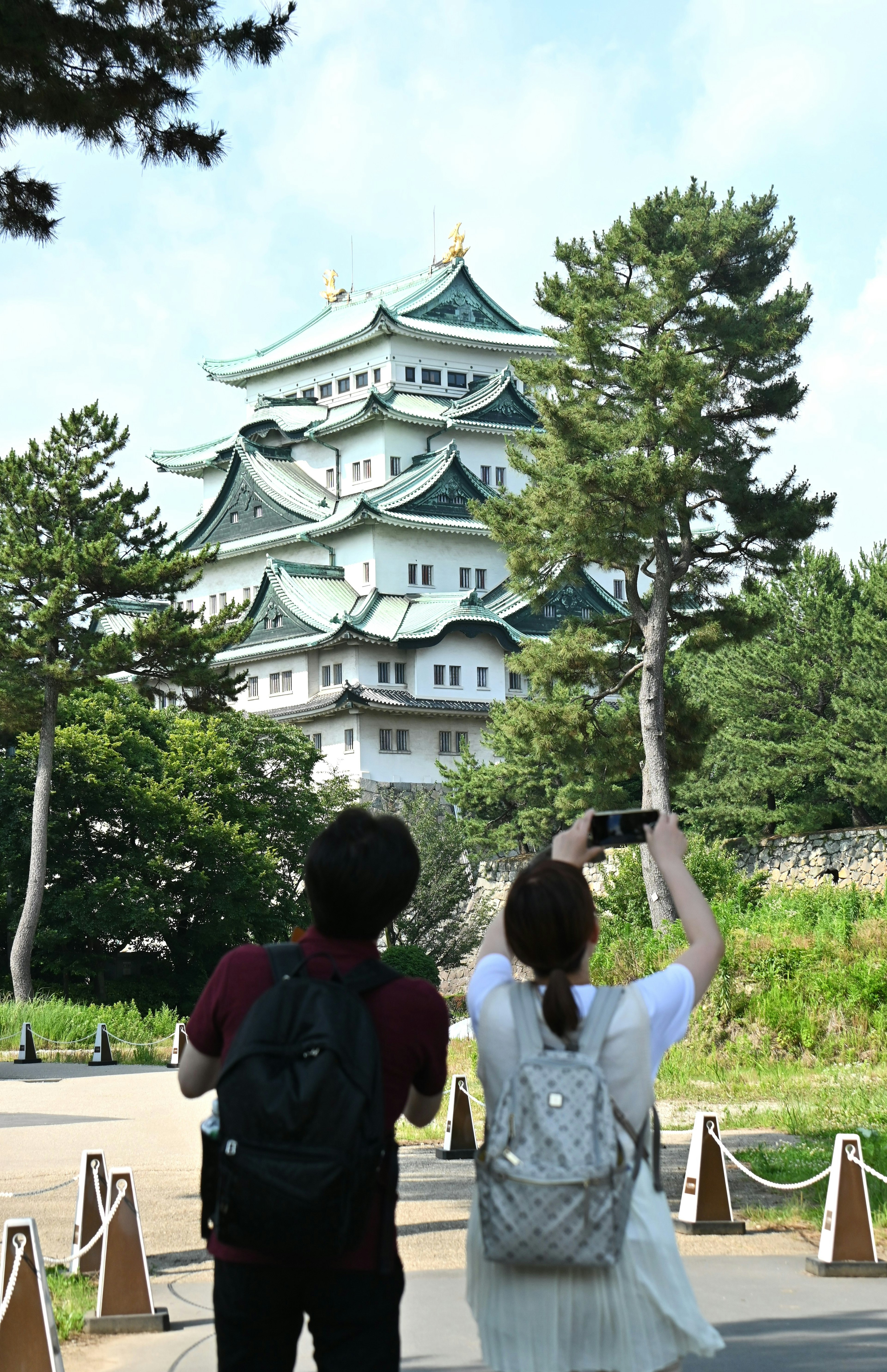 Pareja tomando una foto con el castillo de Nagoya de fondo