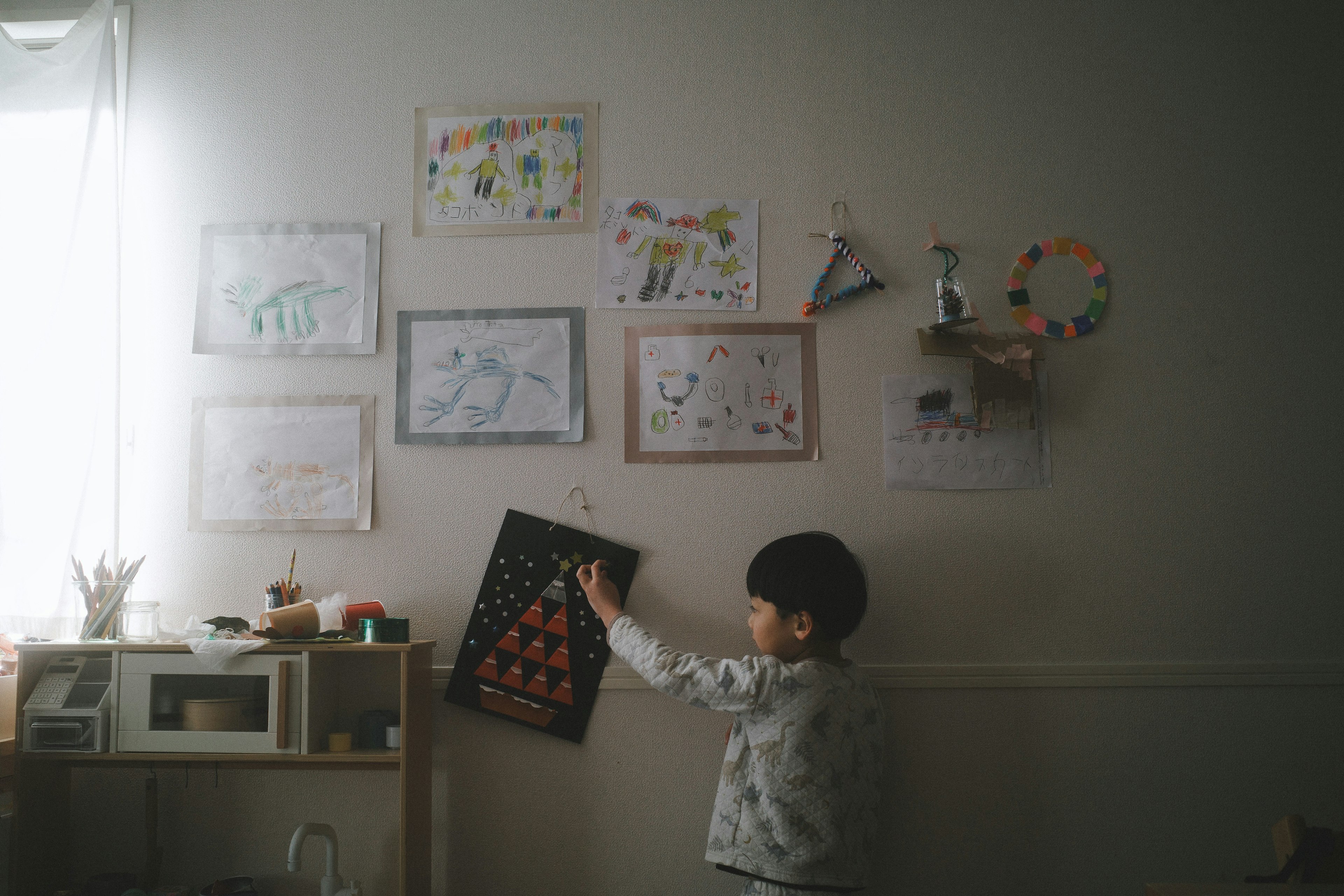 Un enfant observant des dessins sur un mur dans une pièce confortable