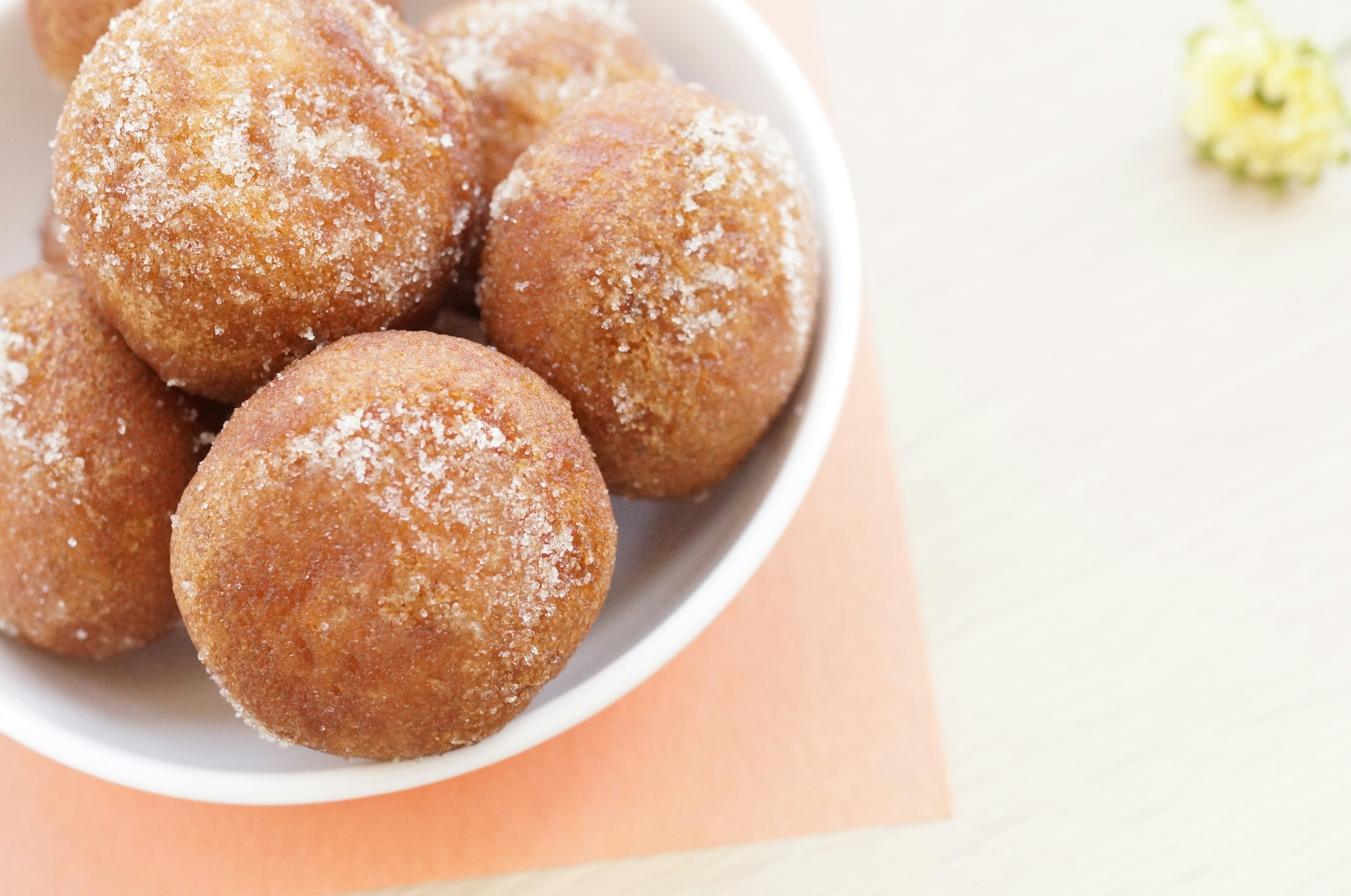 Bolas de masa frita cubiertas de azúcar servidas en un tazón blanco