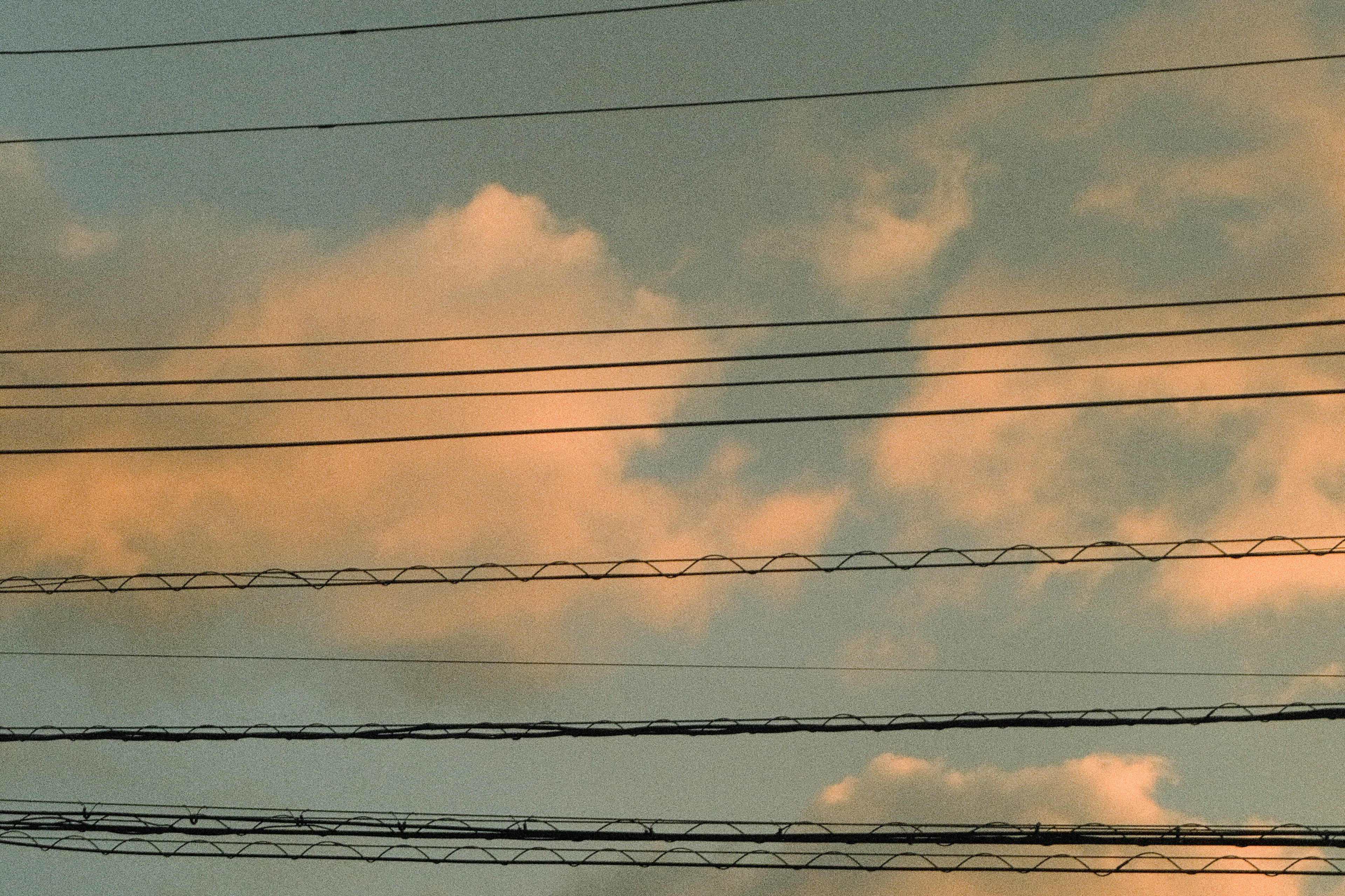 Siluet kabel listrik di latar belakang langit senja