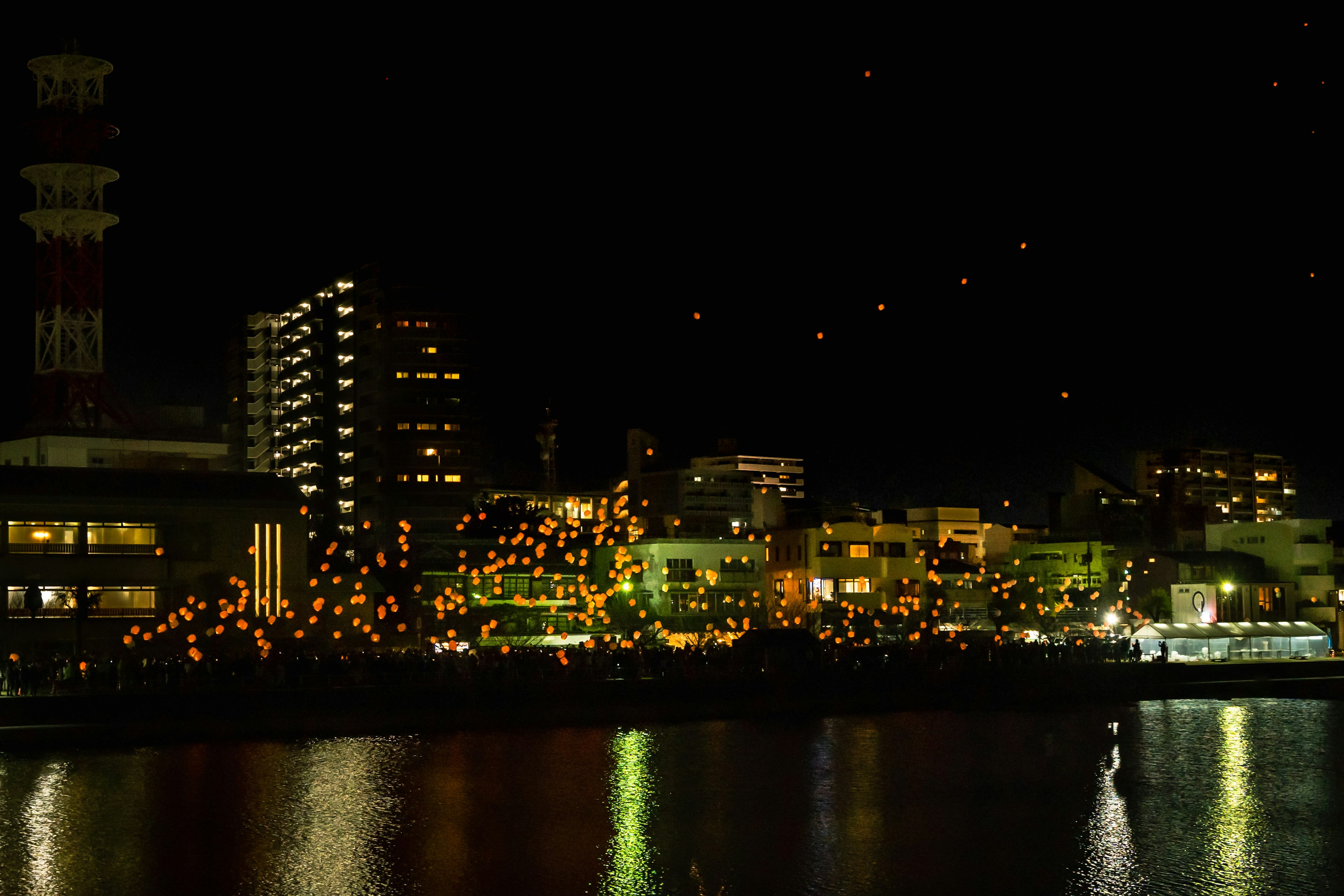 Innombrables lanternes et lumières de la ville brillent le long de la rivière la nuit