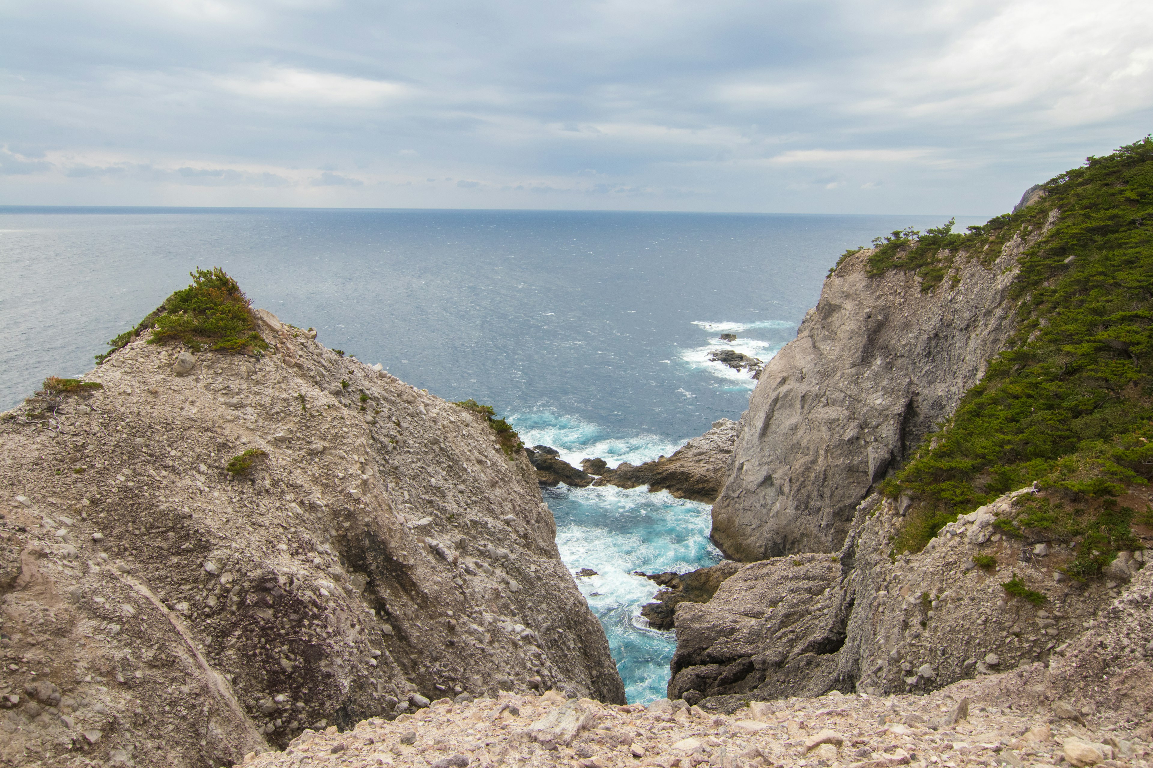 Vue des falaises surplombant l'océan avec une côte rocheuse