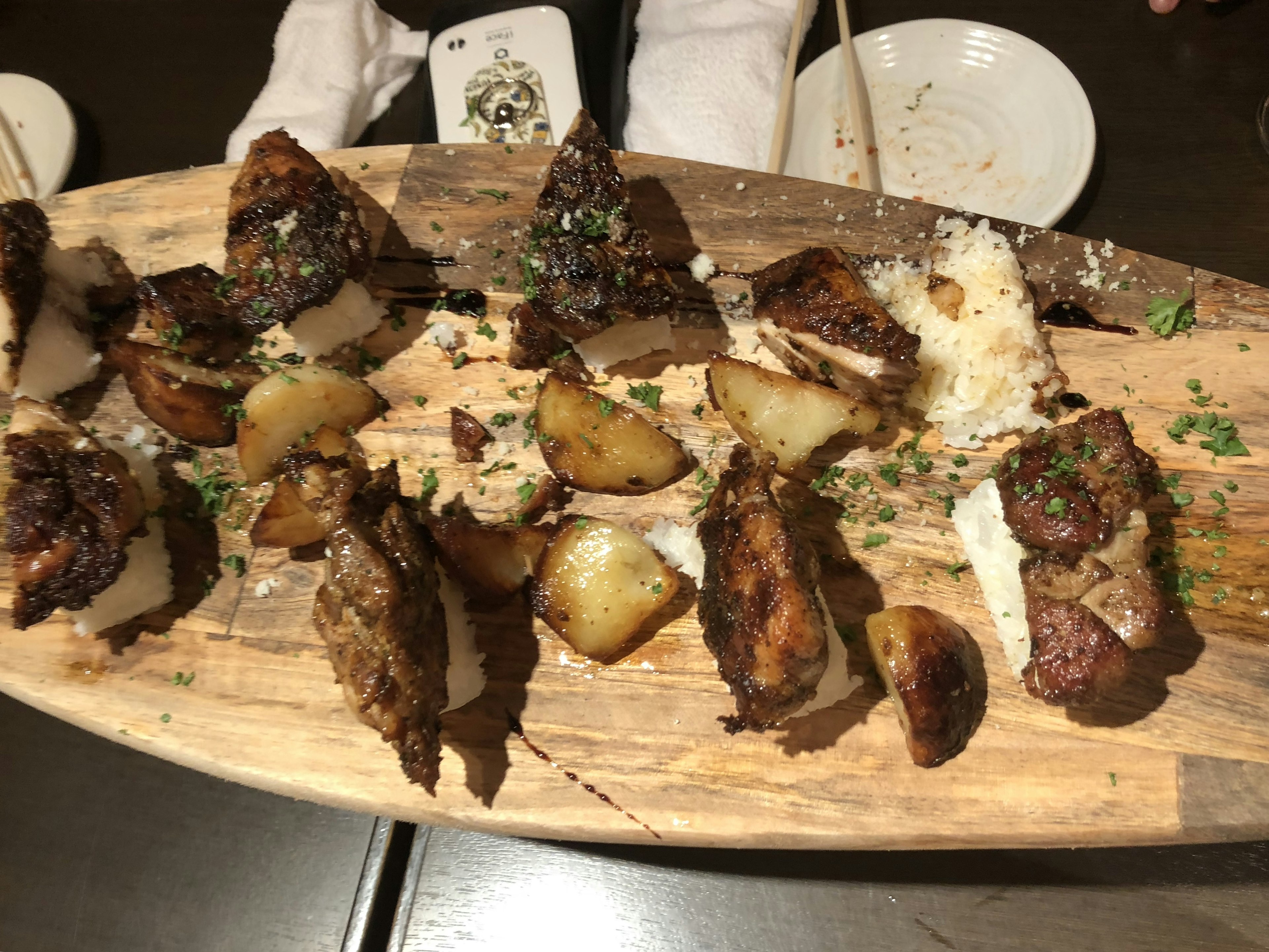 Grilled meat and potatoes served on a wooden platter