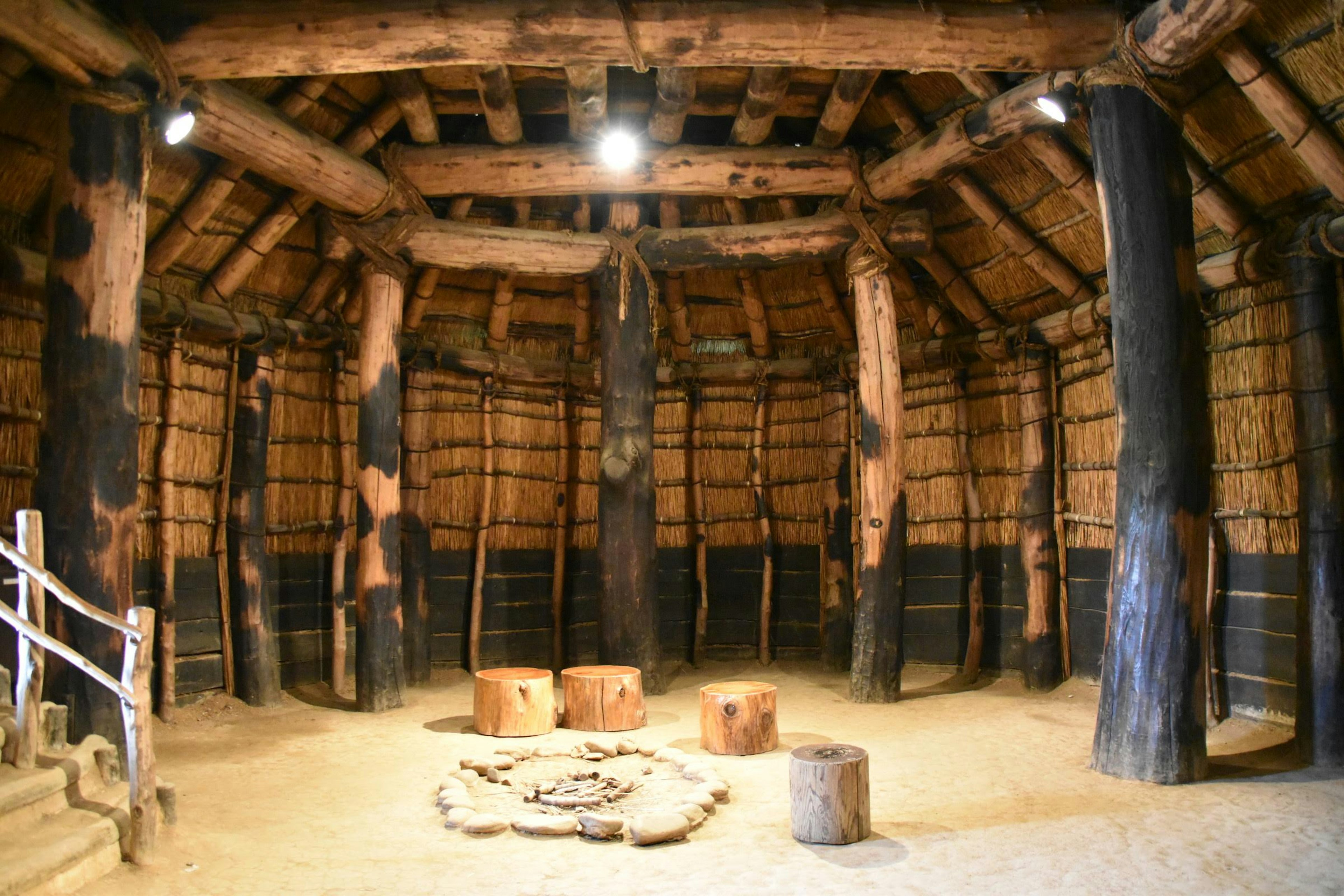 Interior de una antigua sala de reuniones que muestra vigas de madera y paredes de barro