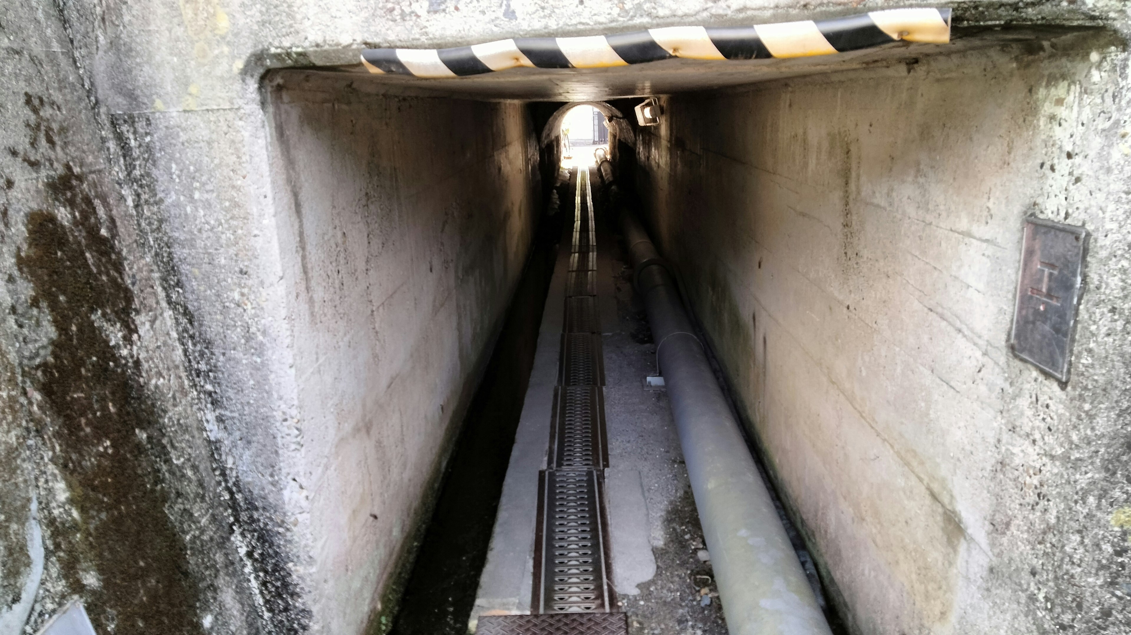 Interior of a dark tunnel featuring railway tracks and walls