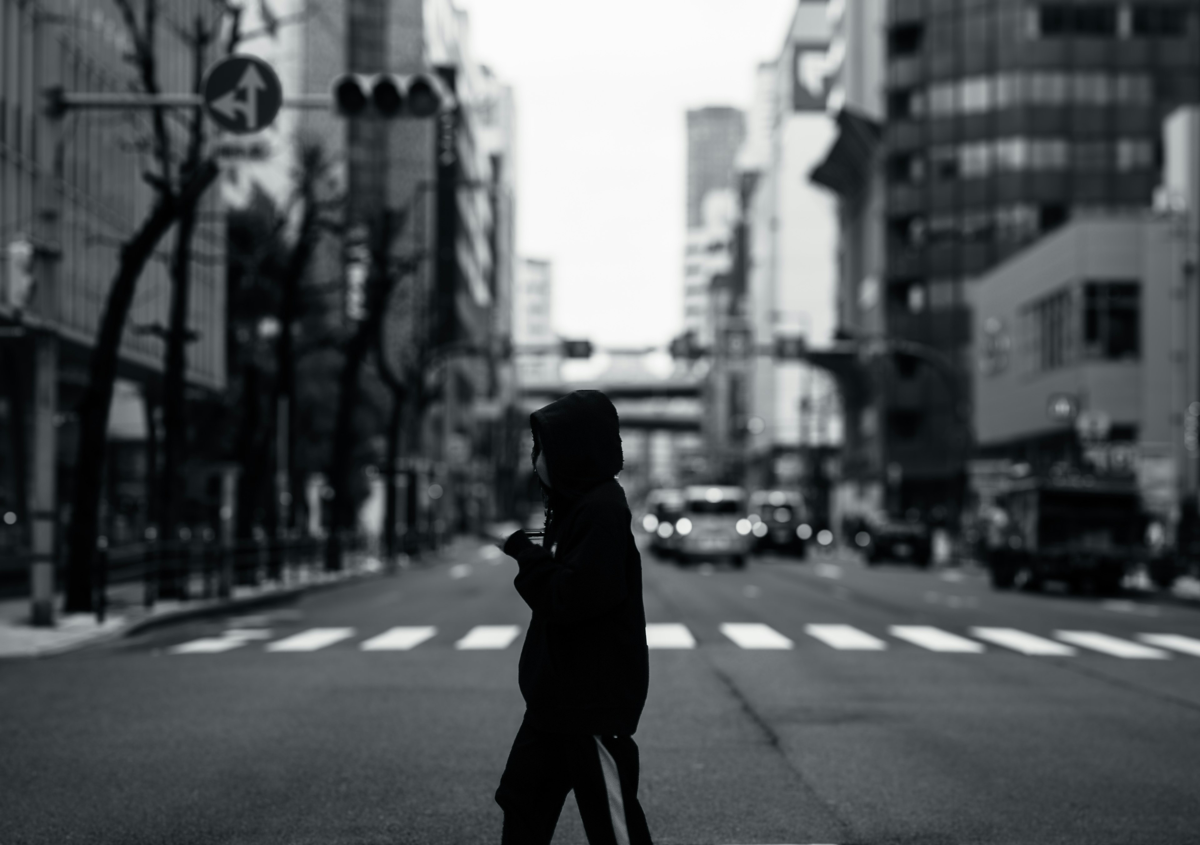 Silueta de una persona cruzando una calle de la ciudad en blanco y negro