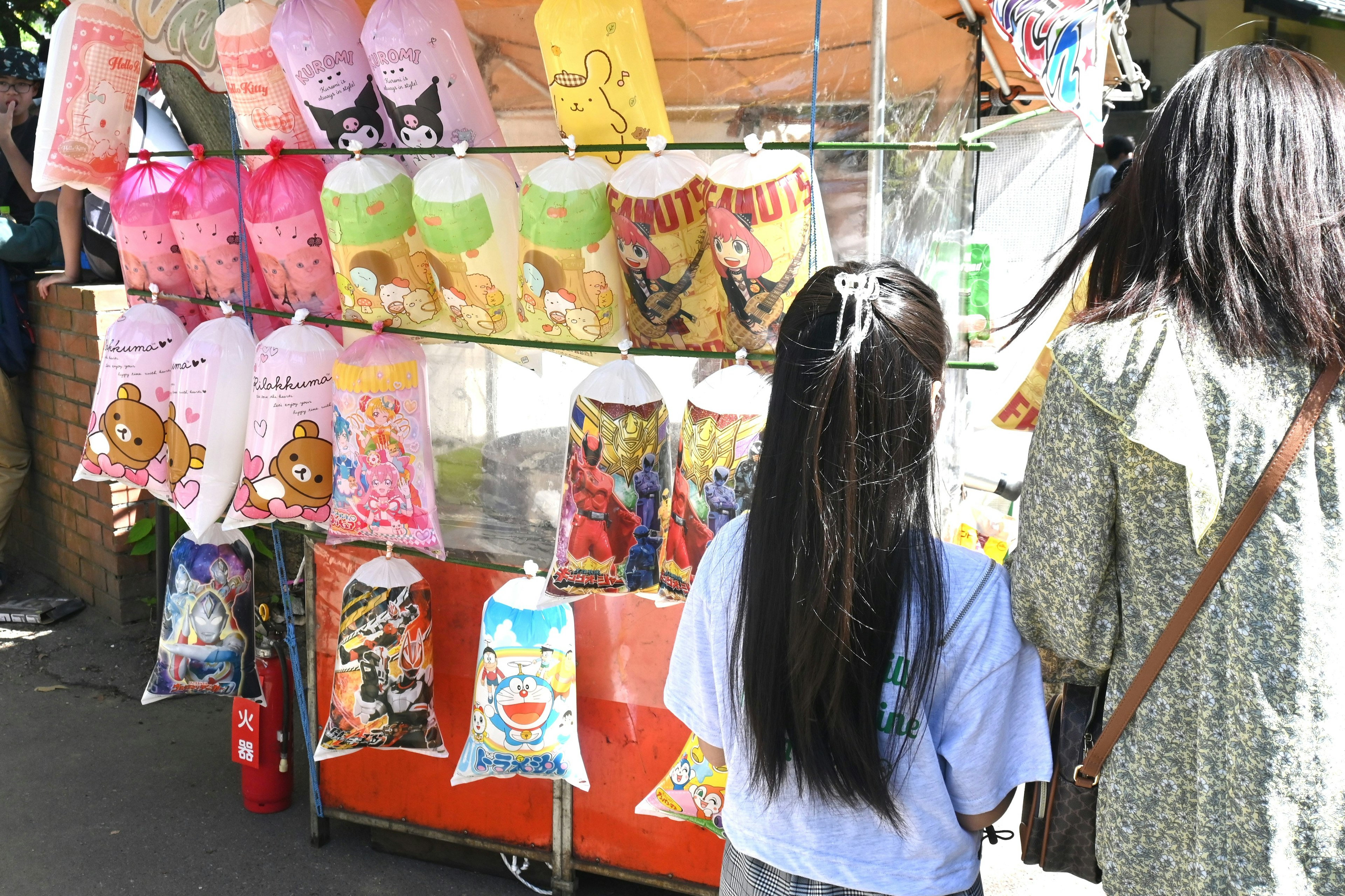 Niños observando bocadillos coloridos en un vendedor callejero