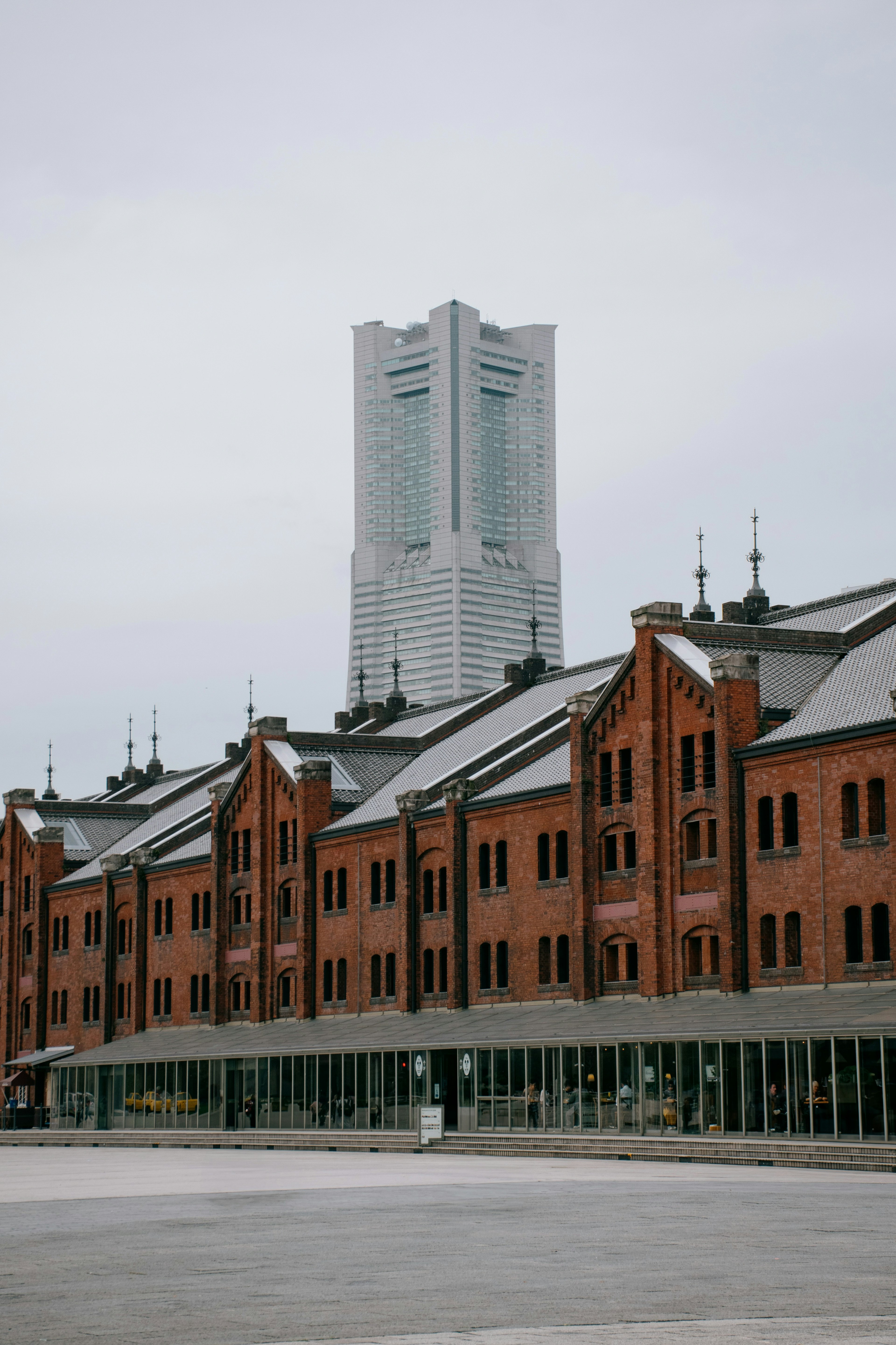 Gudang bata merah Yokohama dengan gedung pencakar langit modern di latar belakang