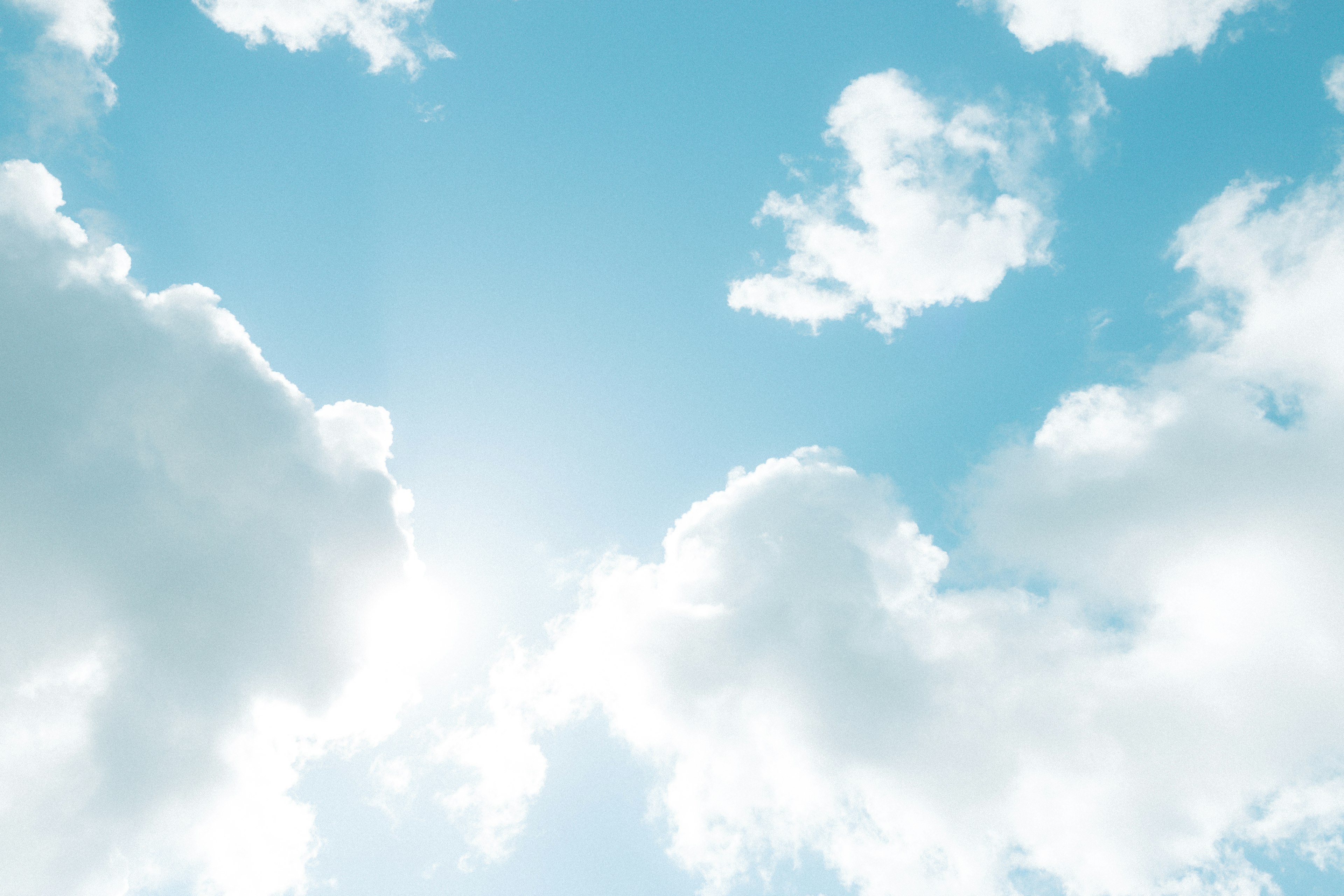 Heller blauer Himmel mit flauschigen weißen Wolken