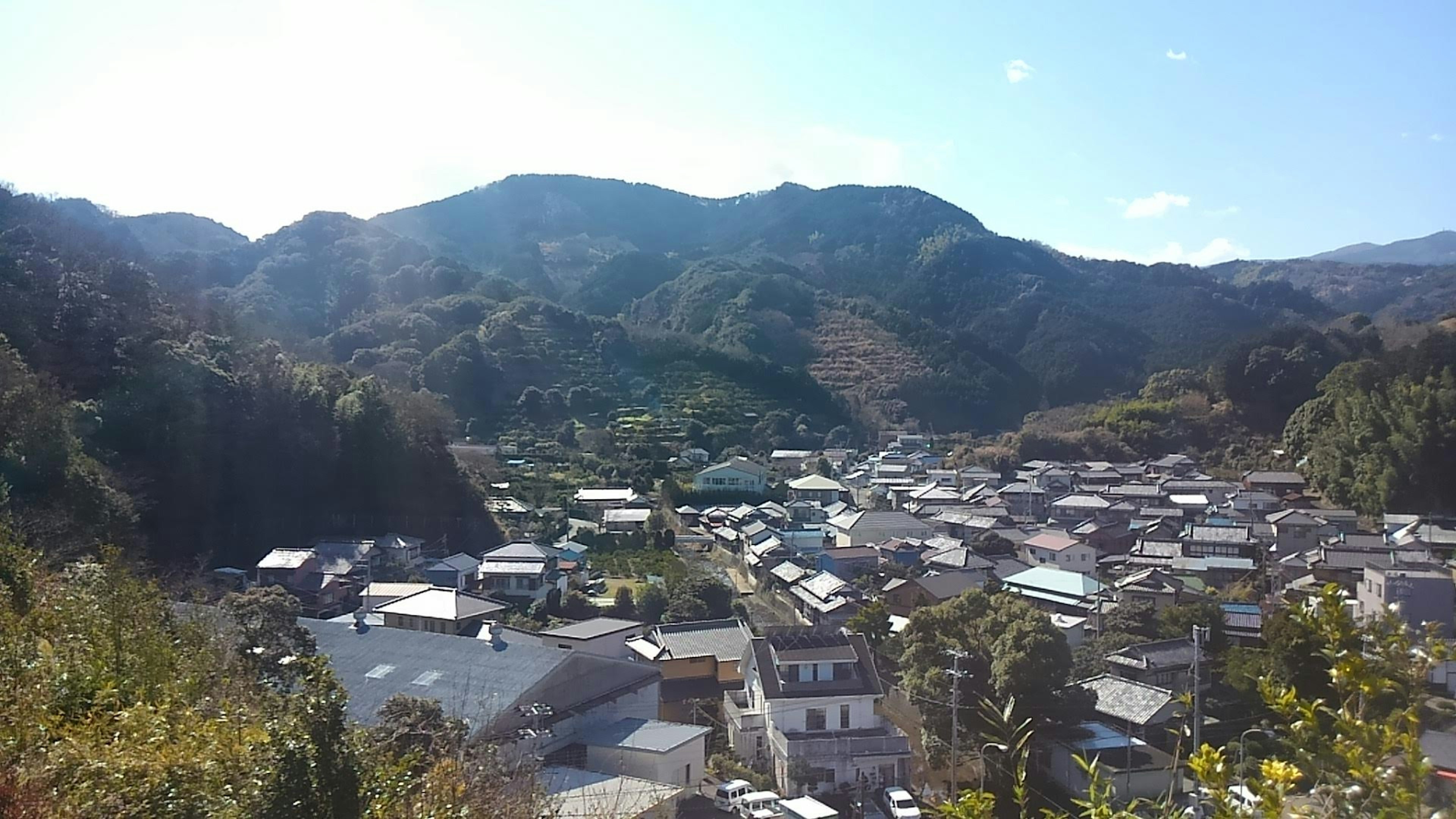 Vue panoramique d'un petit village entouré de montagnes et d'un ciel bleu