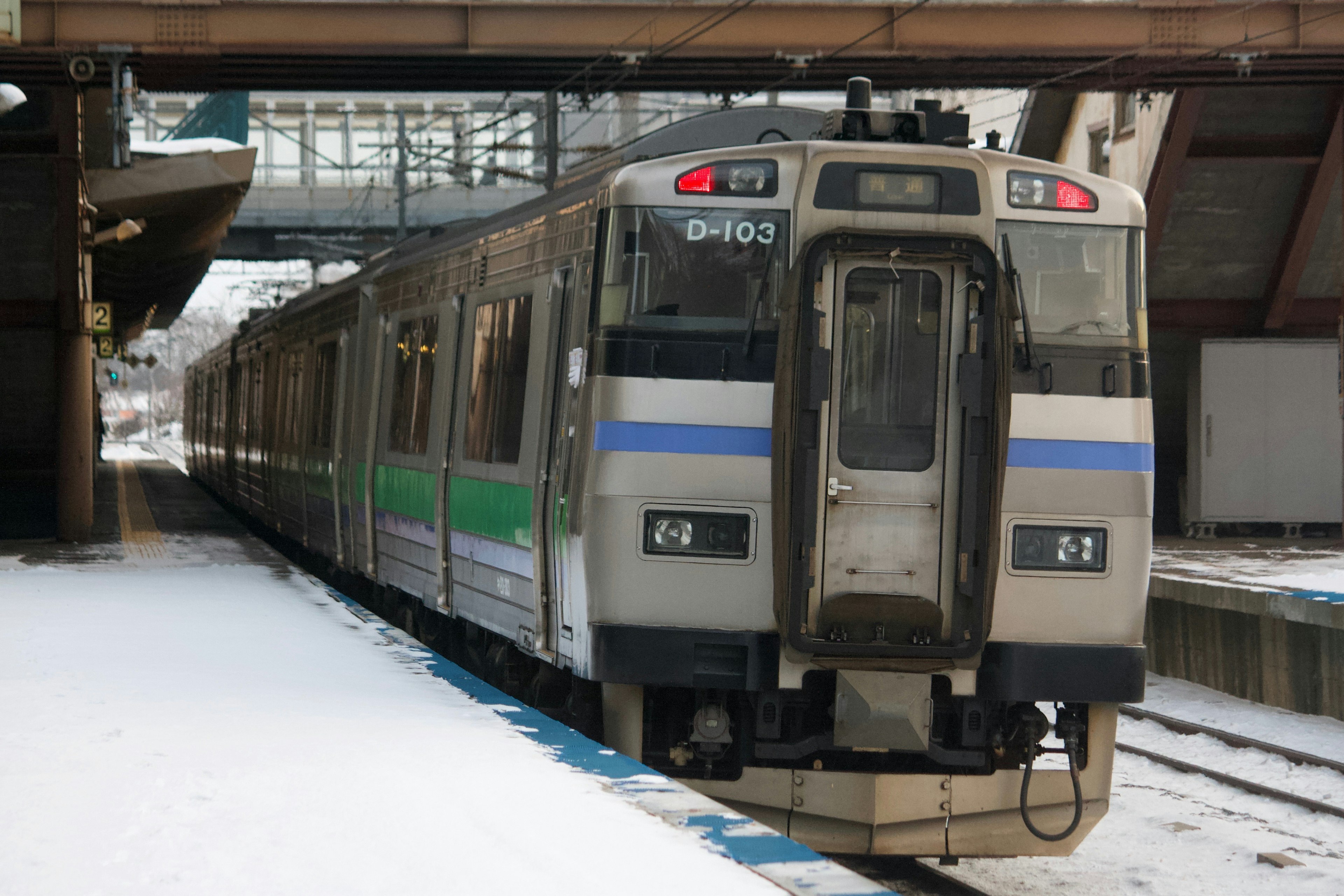 在雪中的車站停靠的火車側面可見