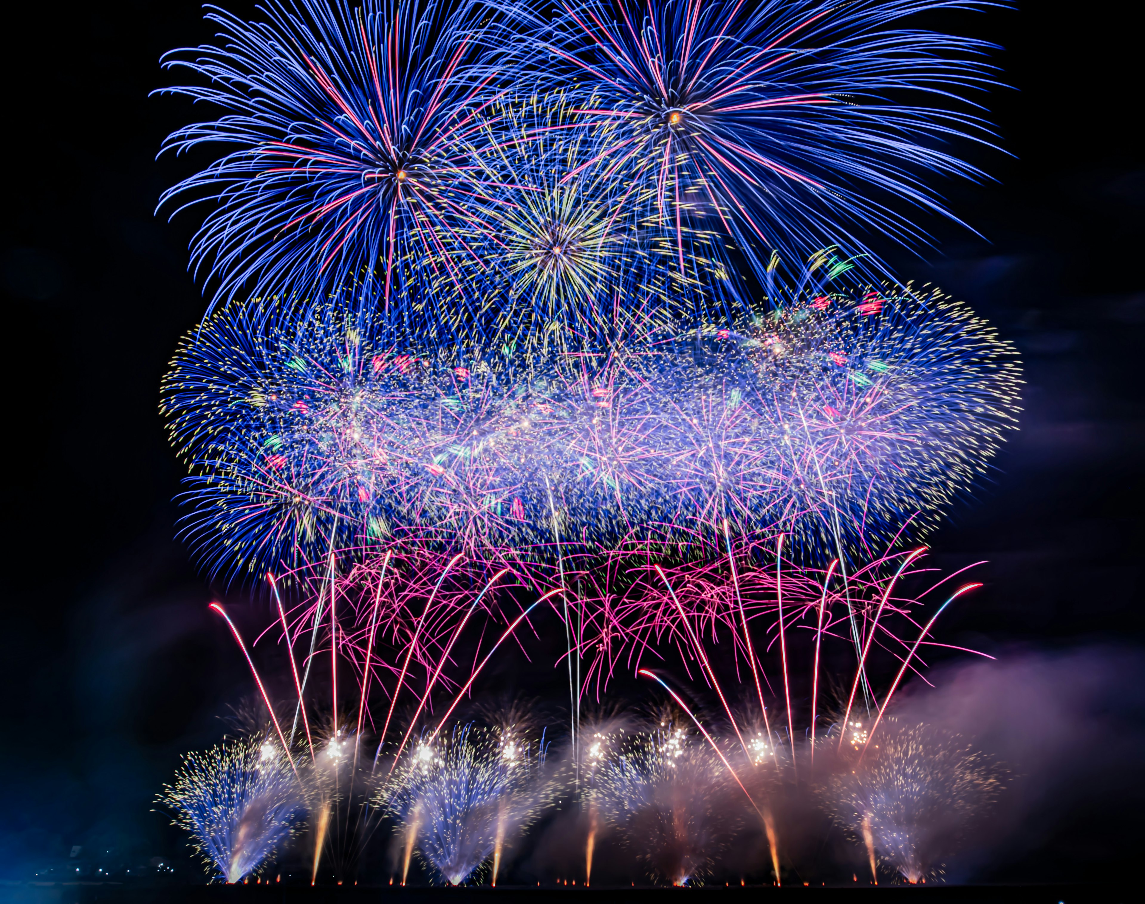 Spectacle de feux d'artifice vibrants dans le ciel nocturne avec des couleurs bleues et violettes