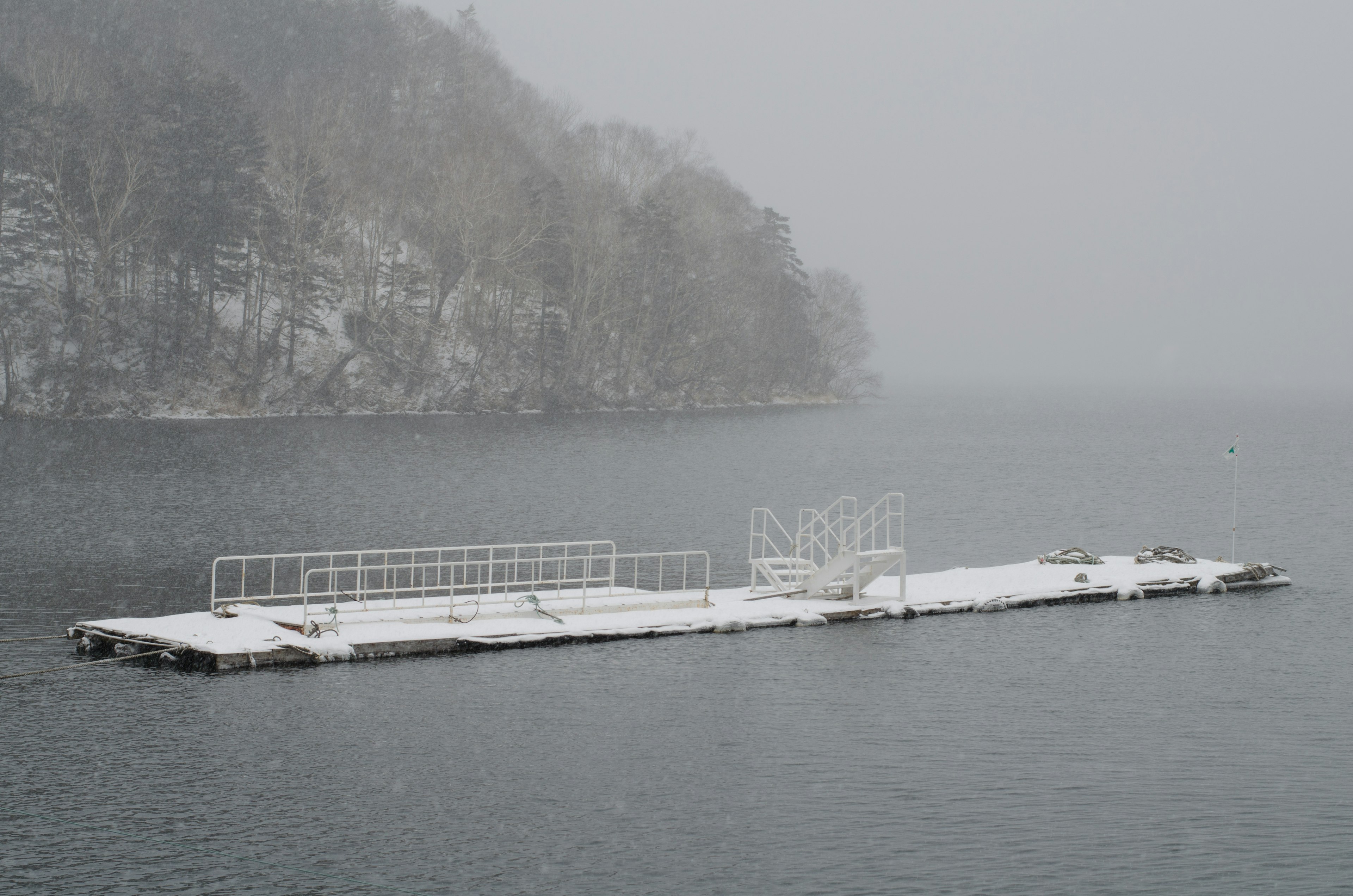 Quai flottant recouvert de neige dans un cadre lacustre serein