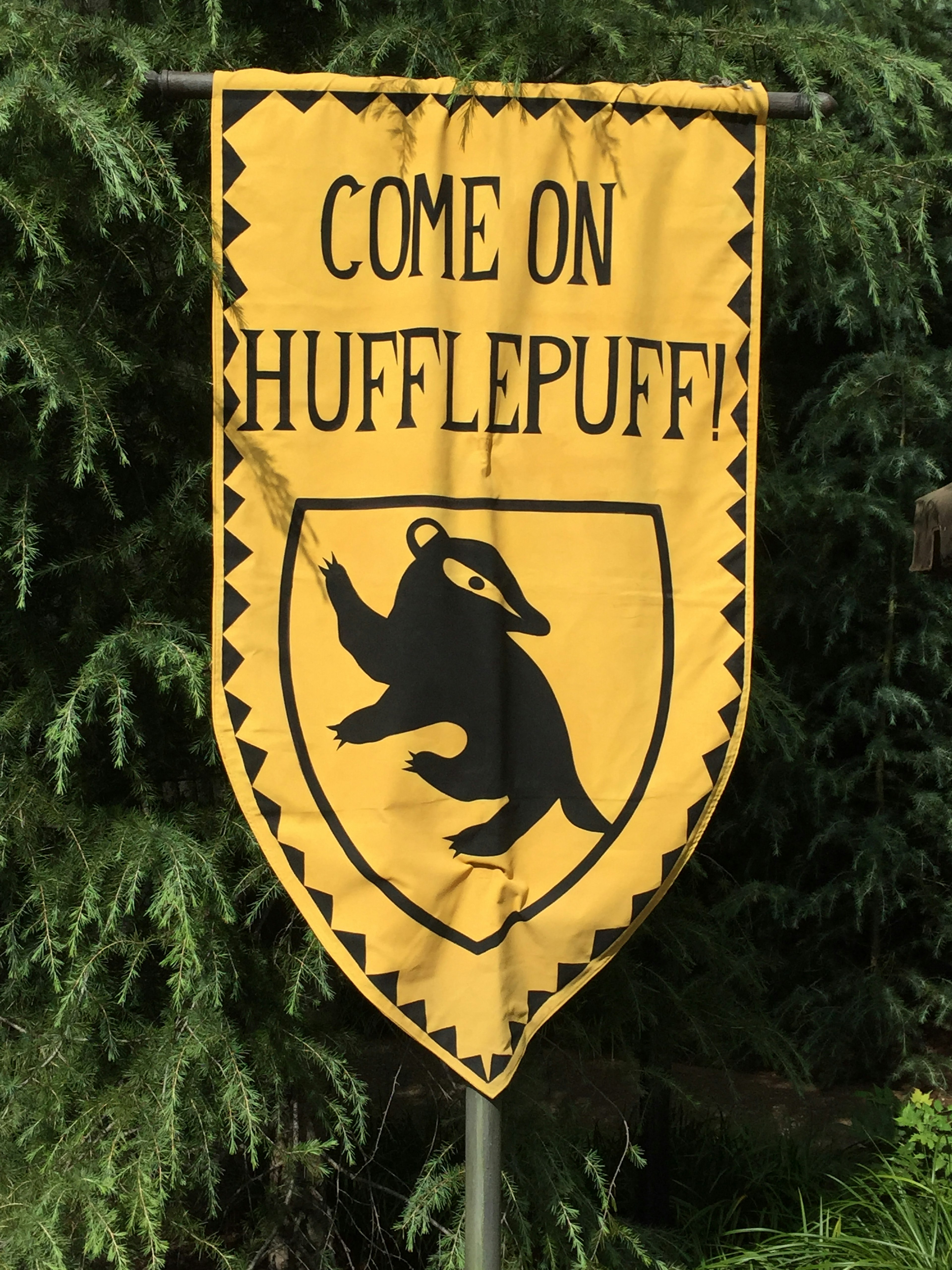 Hufflepuff banner with a yellow background featuring a black badger symbol