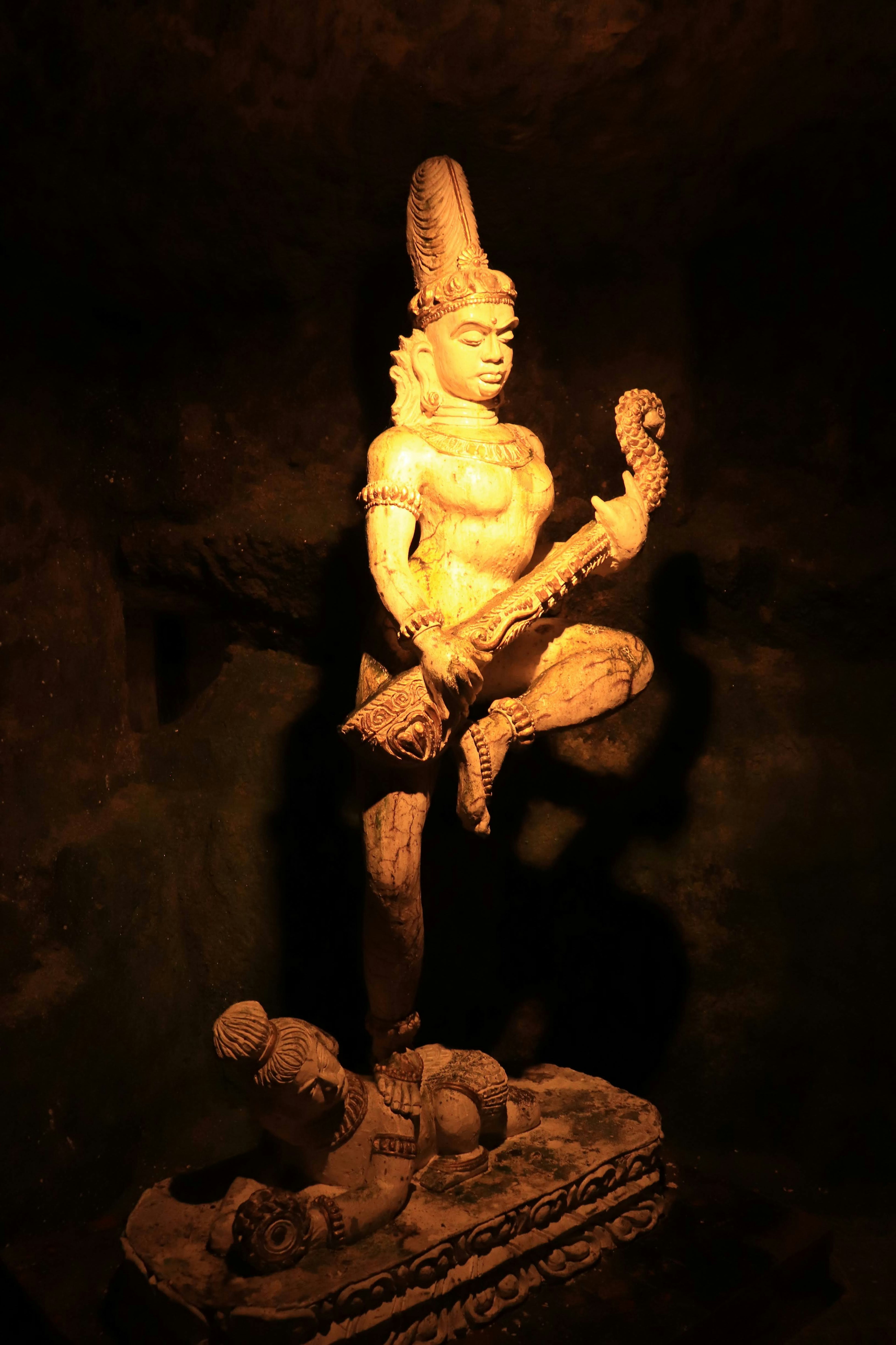 Illuminated sculpture of a Hindu deity inside a cave