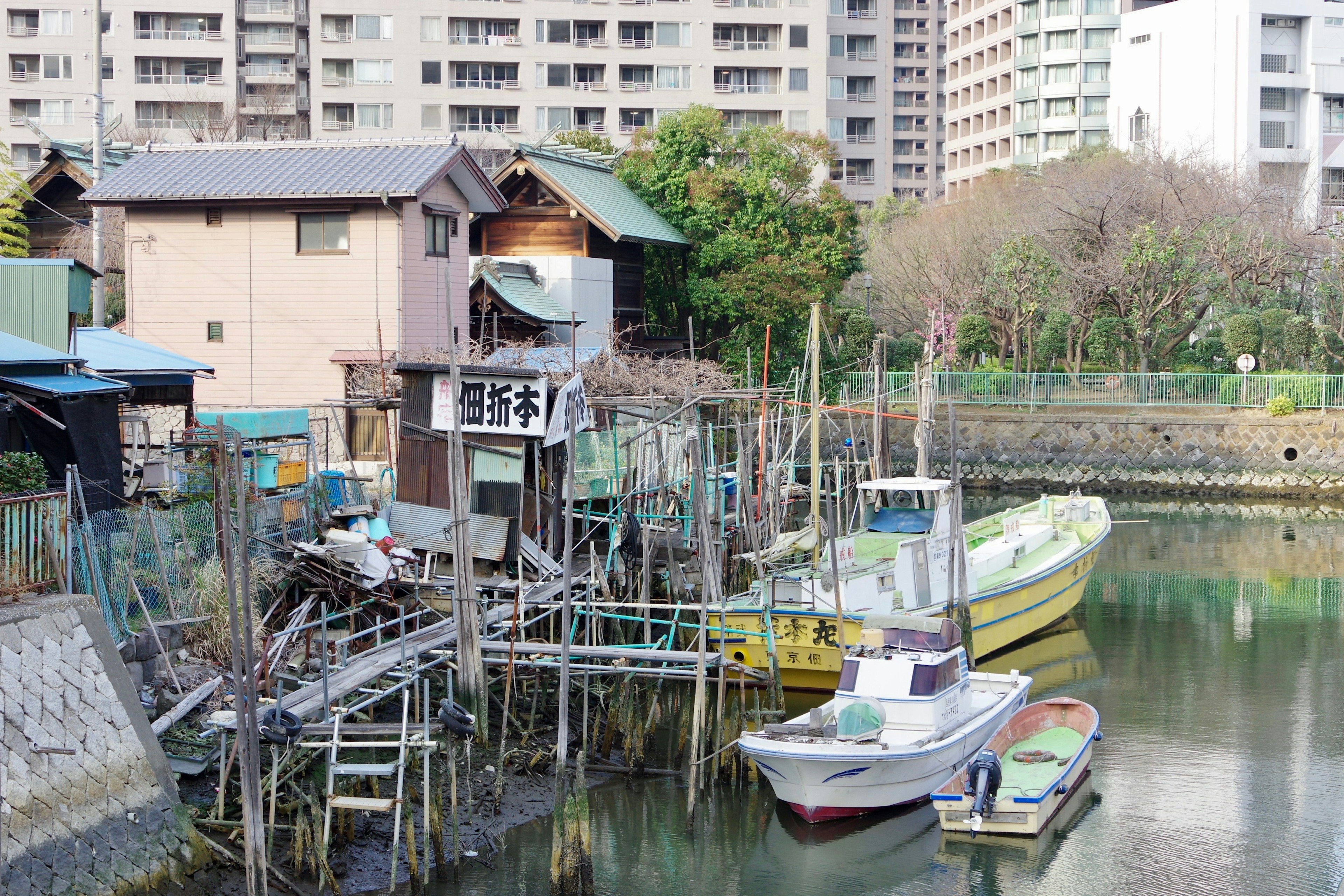 Vista de una casa de madera antigua y barcos a lo largo de un canal