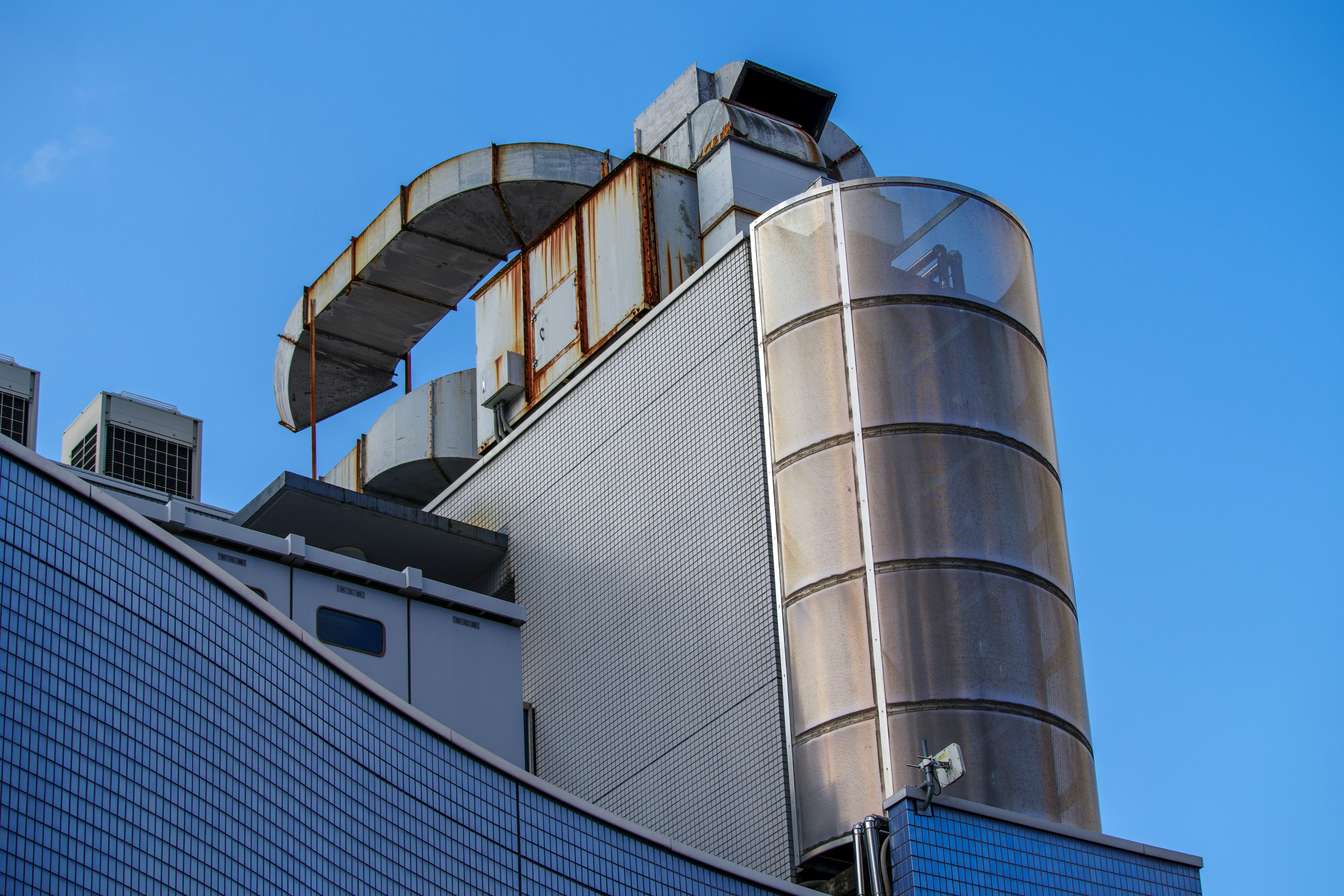 Obere Struktur eines Industriegebäudes mit moderner Architektur vor blauem Himmel