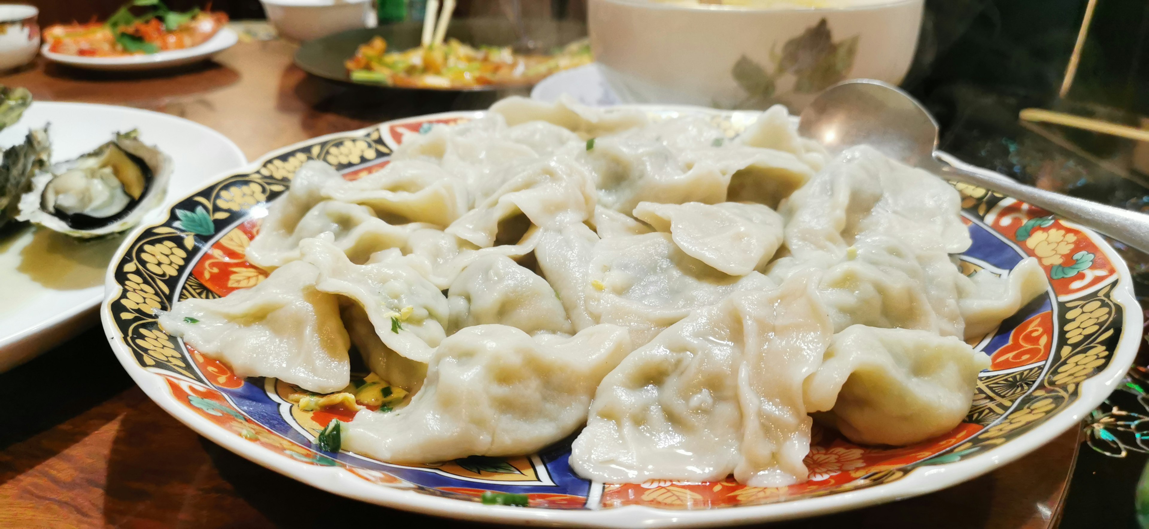 Plate of boiled dumplings with intricate designs around the edge