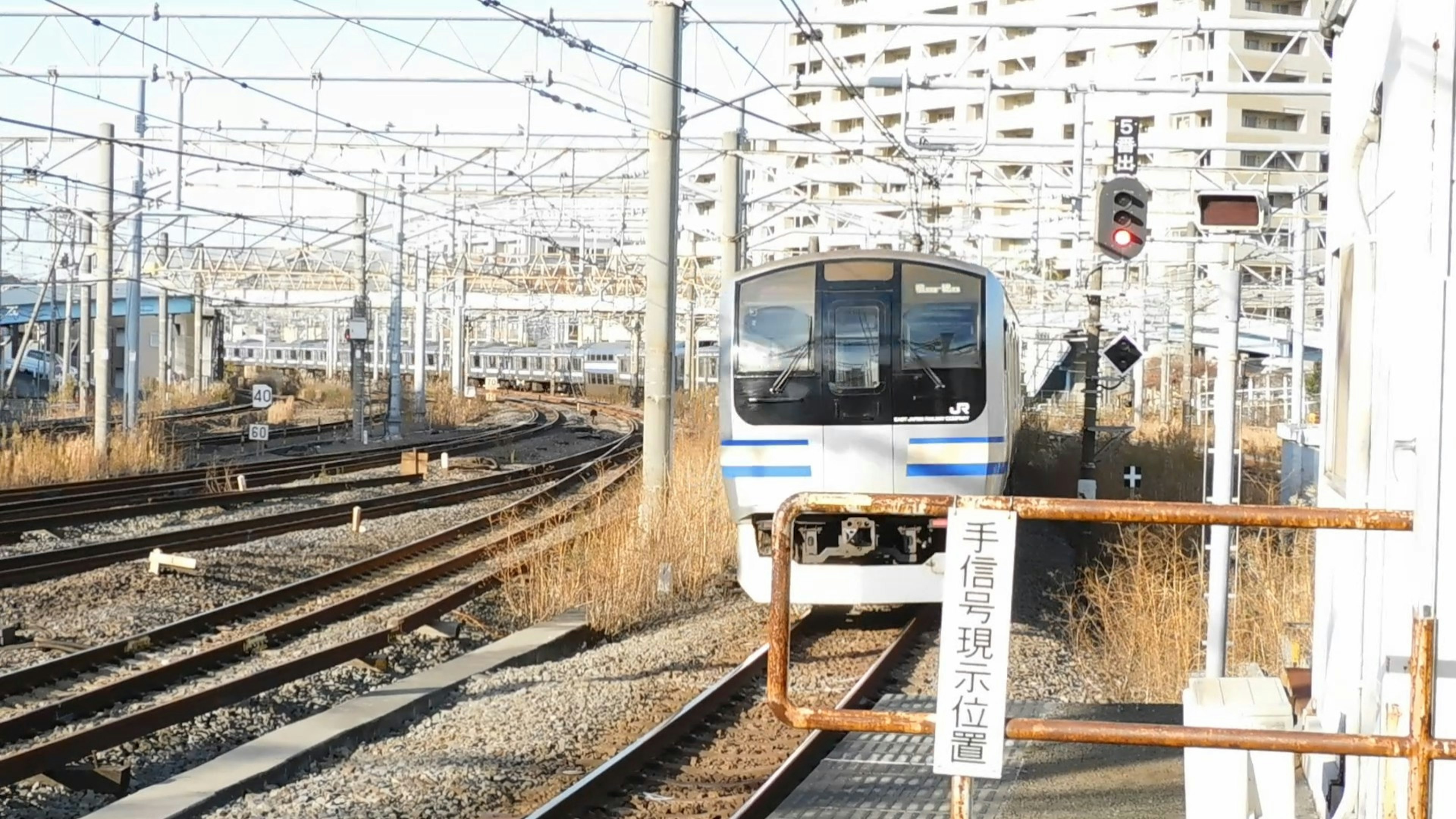 Train s'approchant d'un signal dans une gare ferroviaire avec plusieurs voies