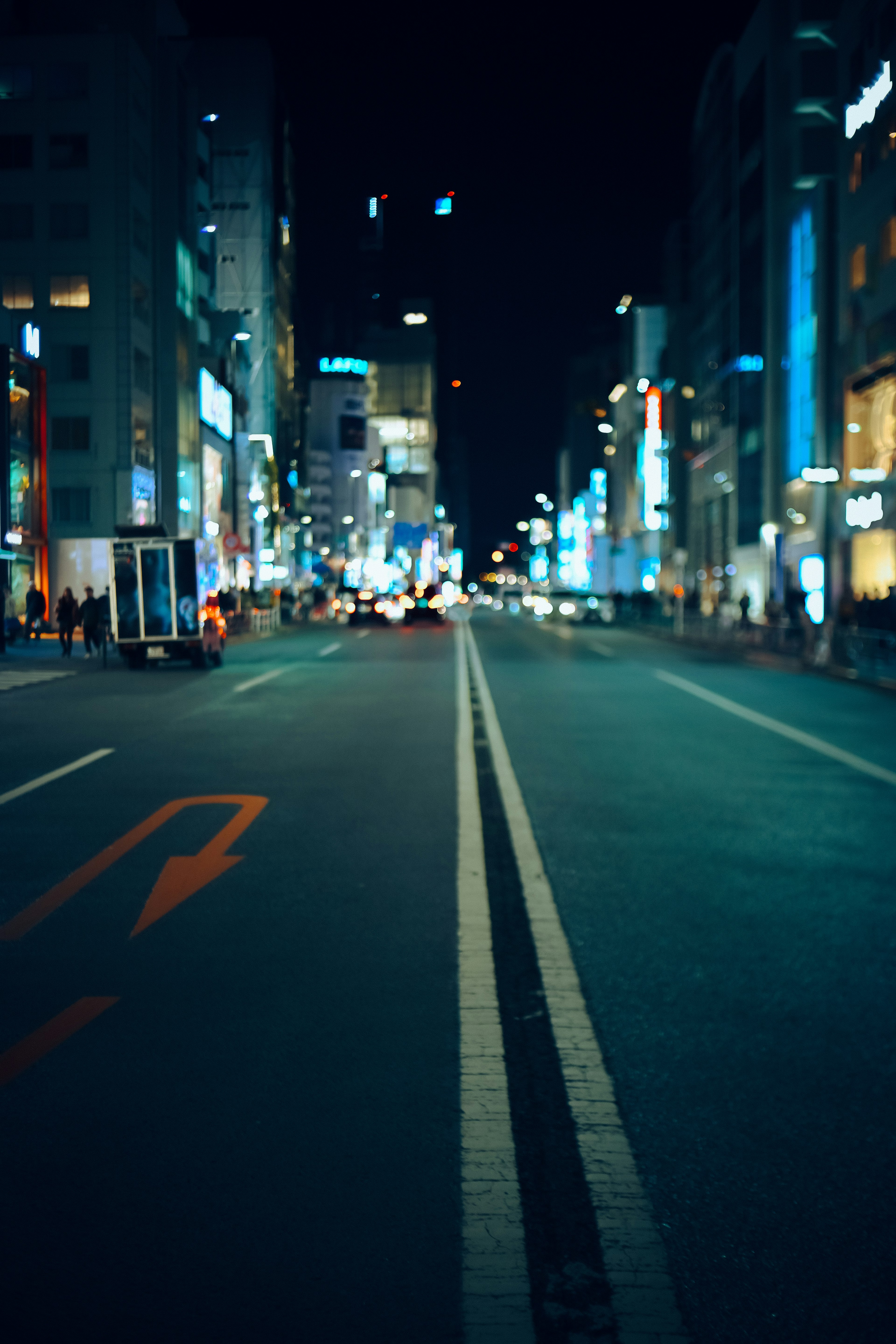 夜の都市の通りの写真 明るいネオンの看板と空いている車線