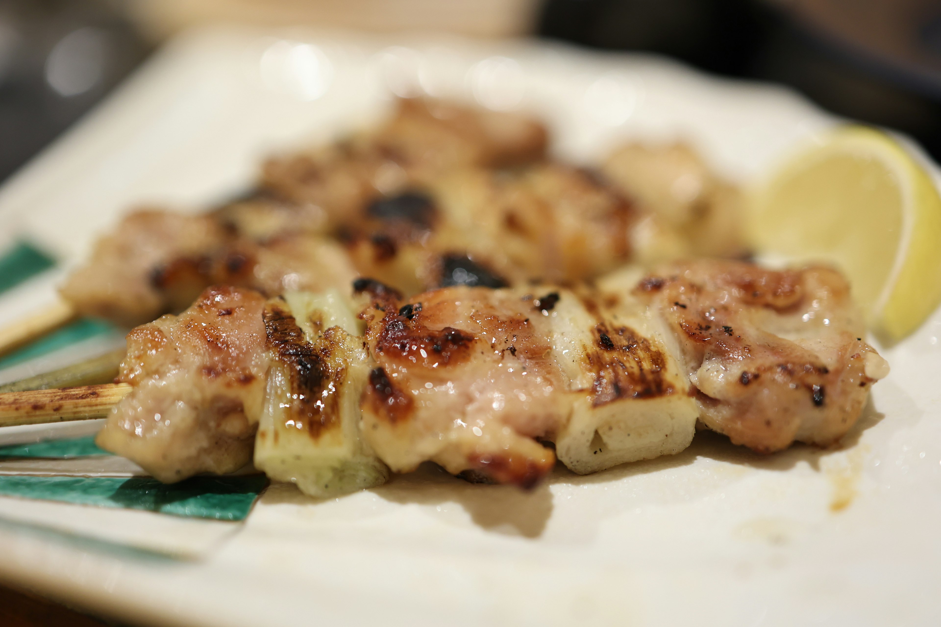 Grilled chicken skewers served with lemon slices on a plate