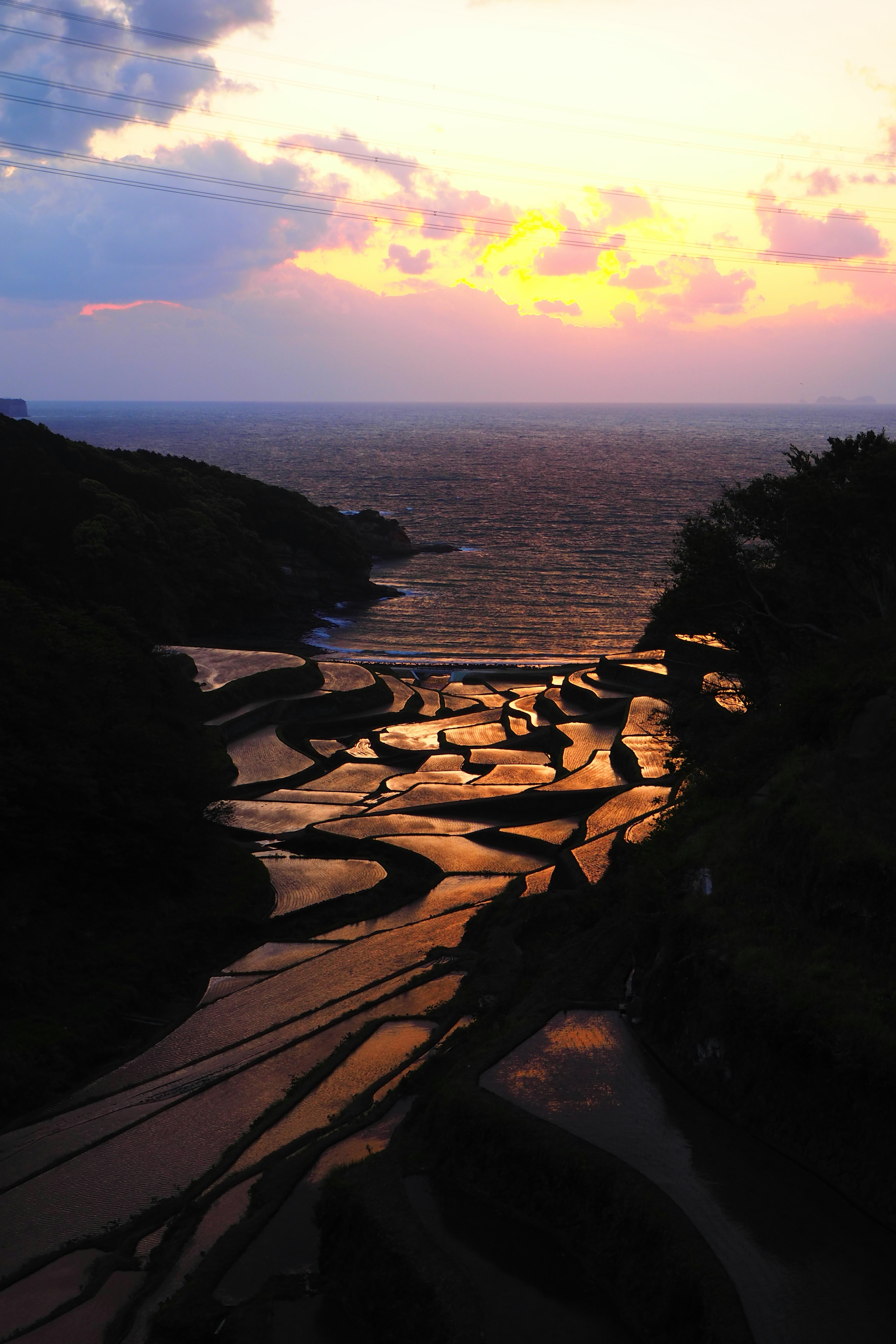 Garis pantai yang indah dengan warna matahari terbenam dan pola batu