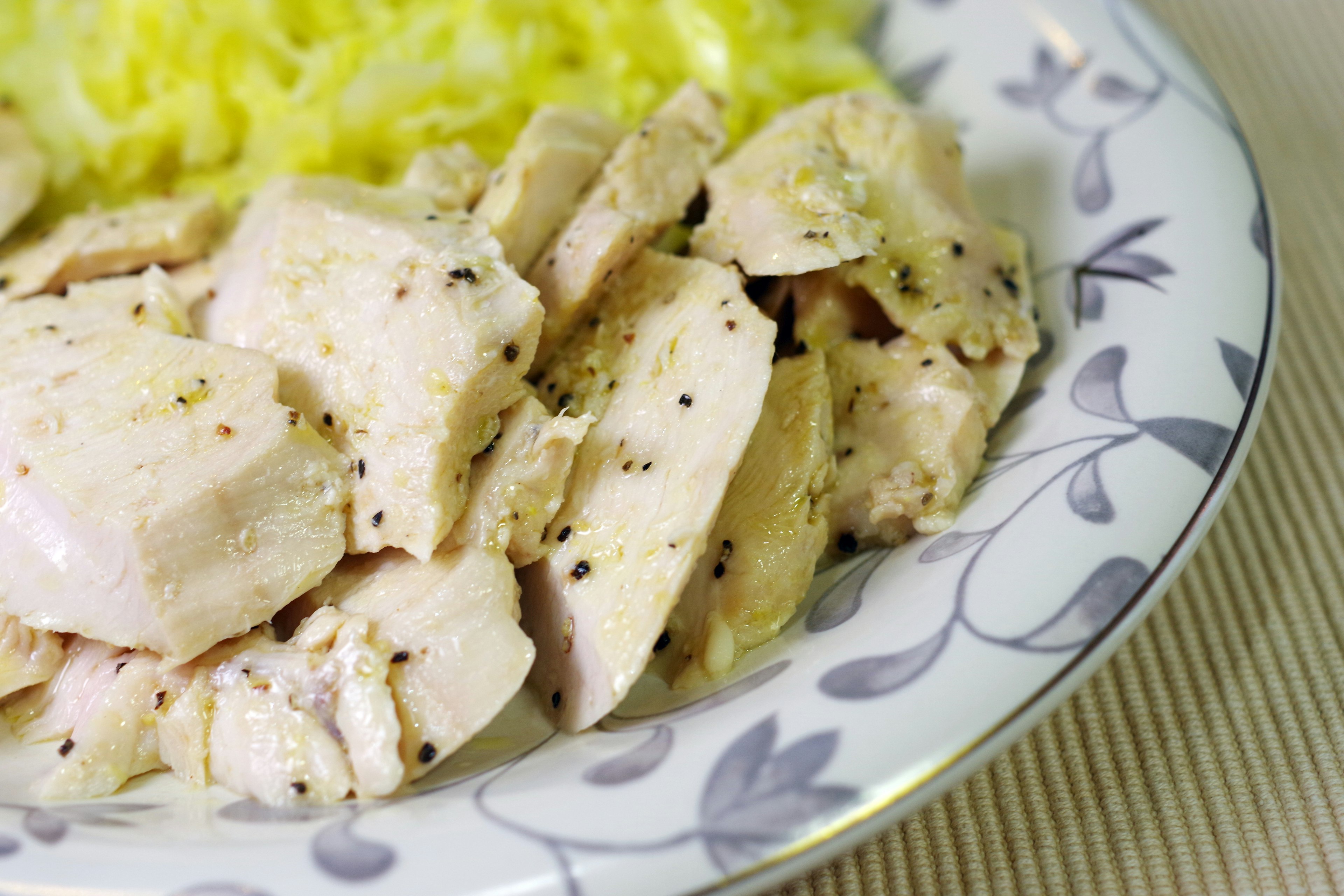 Poulet tranché servi avec du riz jaune sur une assiette décorée