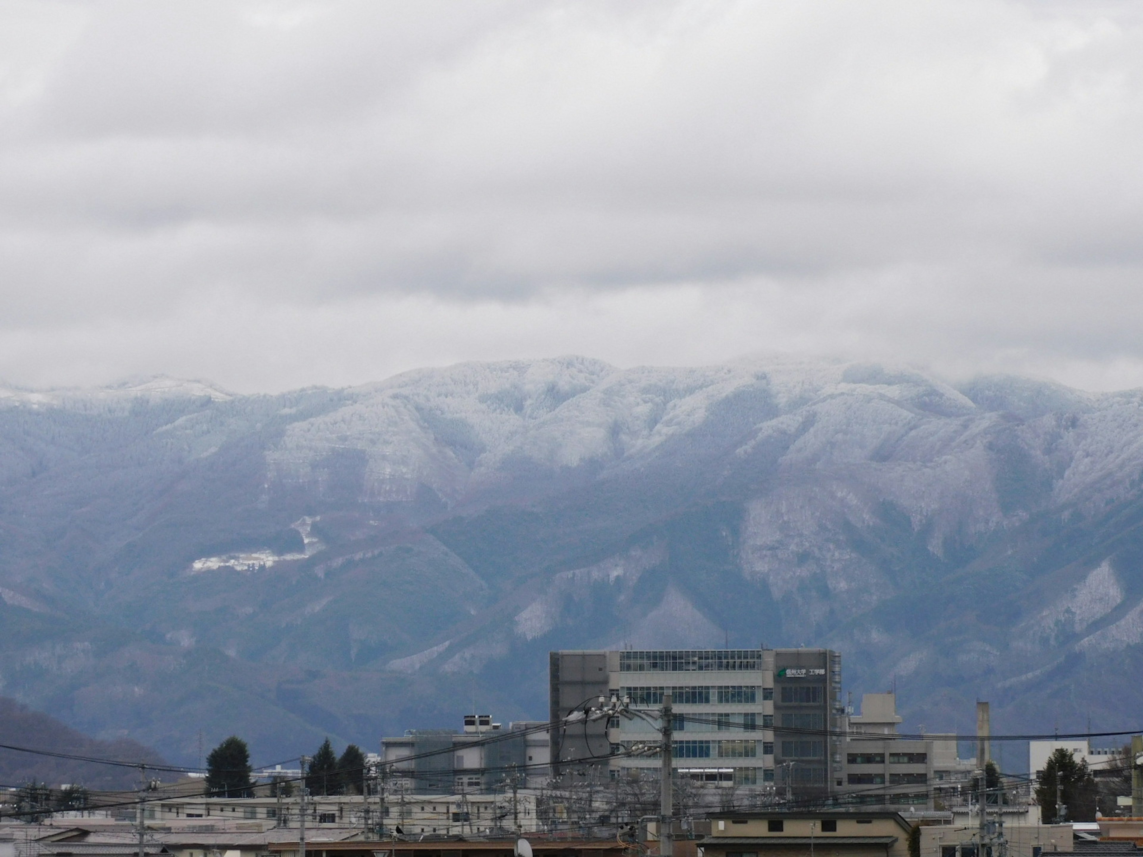 Montagne innevate con un paesaggio urbano in primo piano