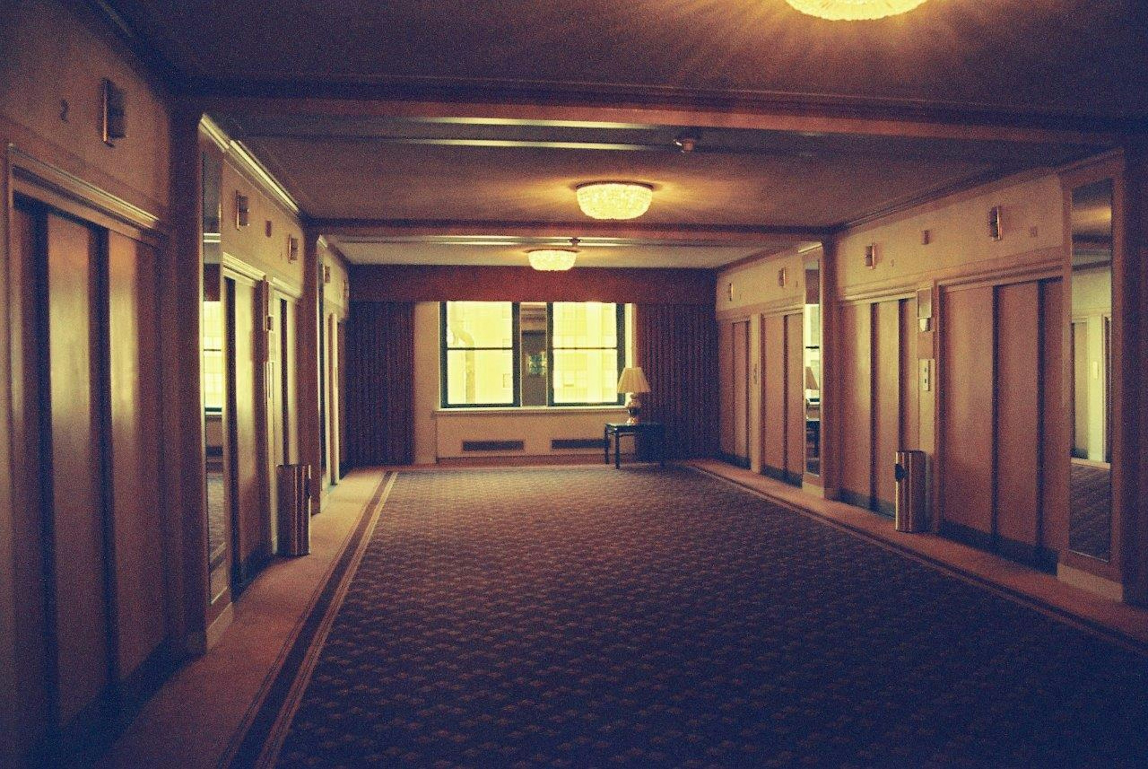 Interior view of a spacious lobby featuring elevators warm lighting and a cozy atmosphere