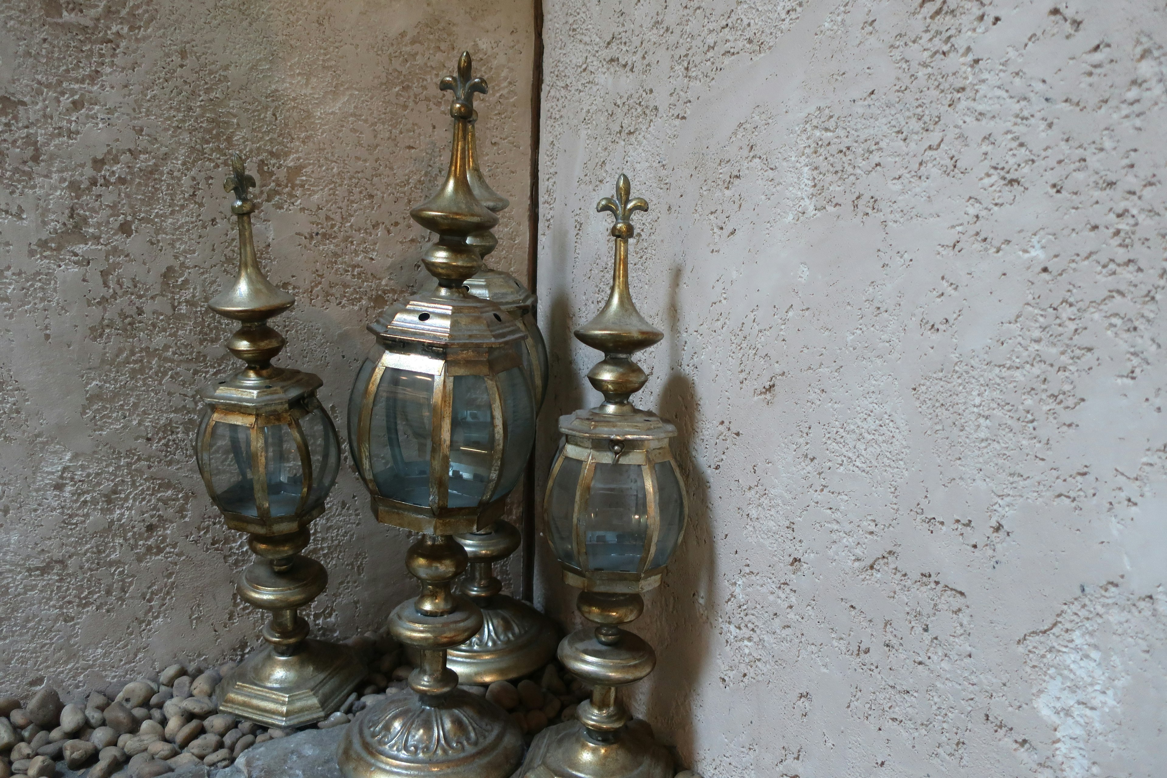 Image of decorative metal lamps arranged against a wall