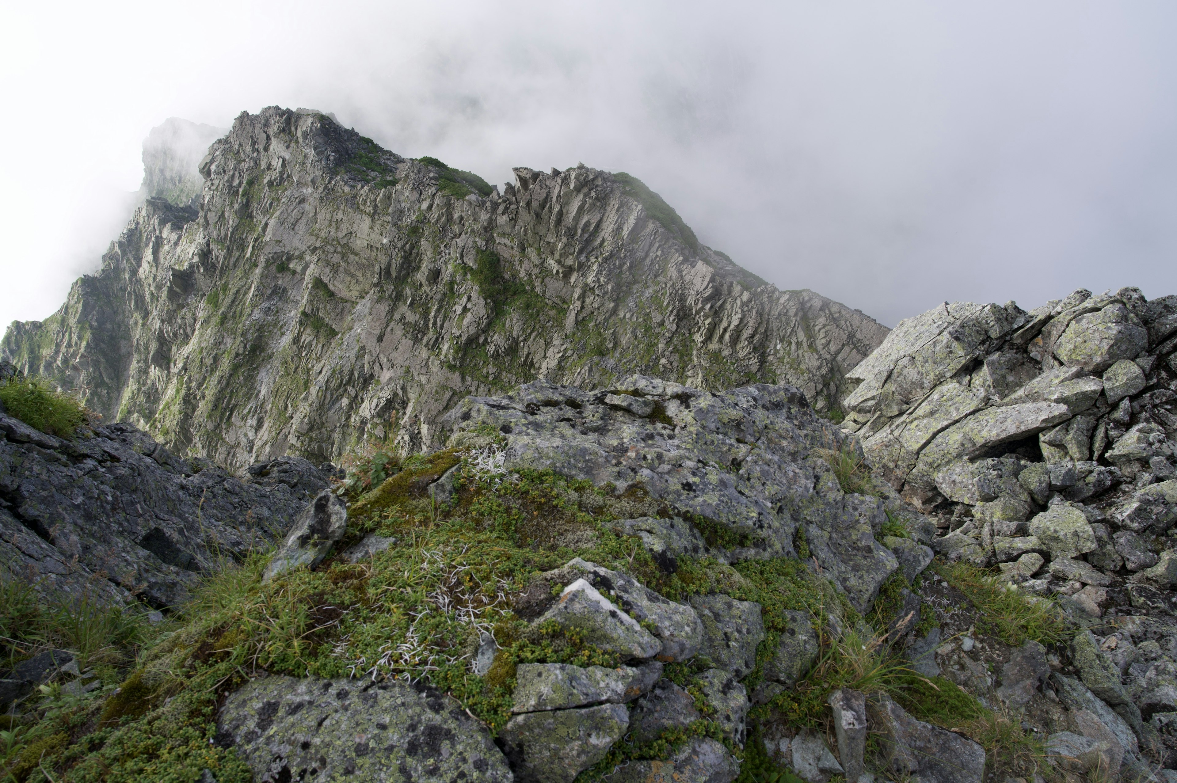 Paesaggio montano avvolto nelle nuvole con terreno roccioso