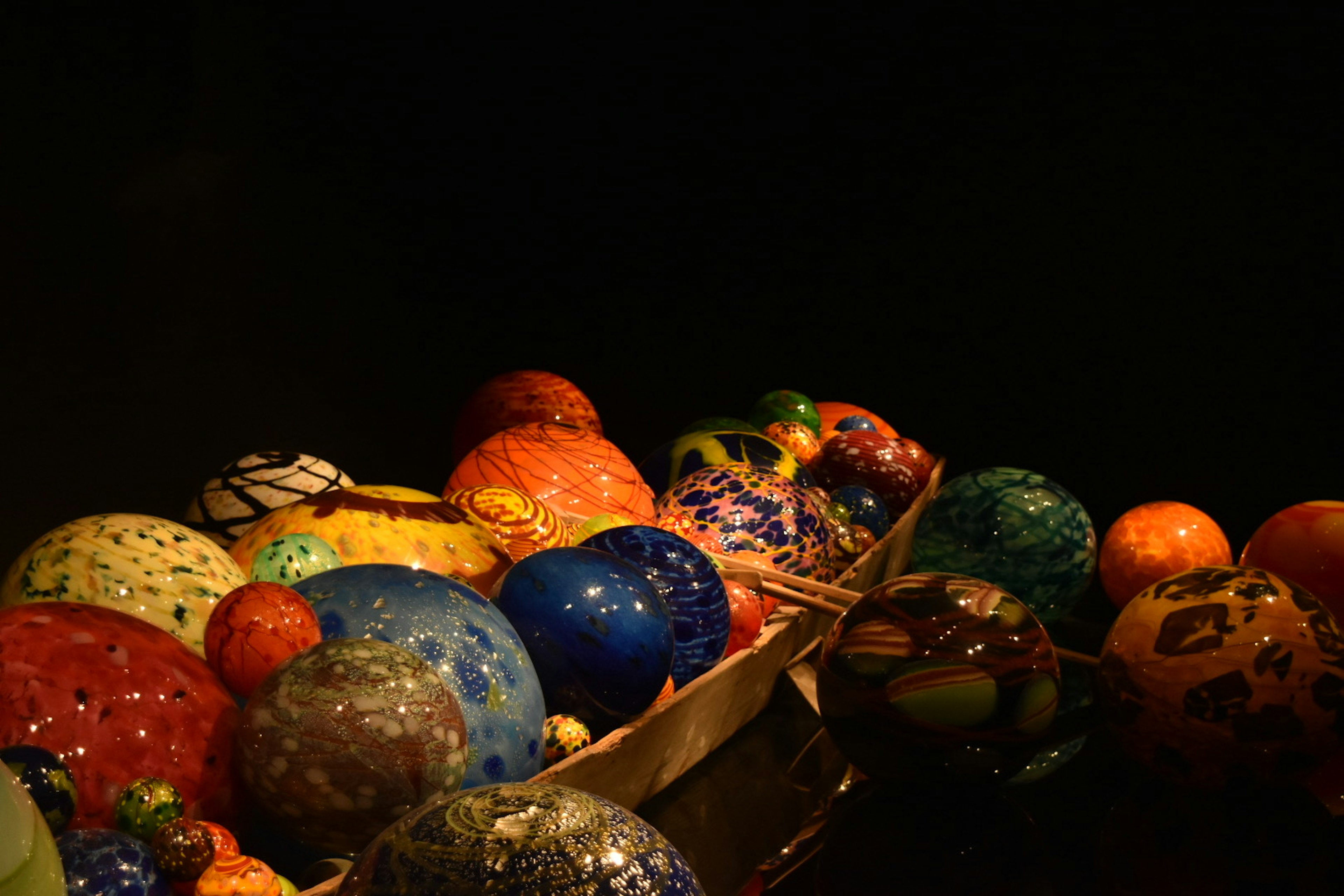 Colorful glass orbs arranged against a dark background