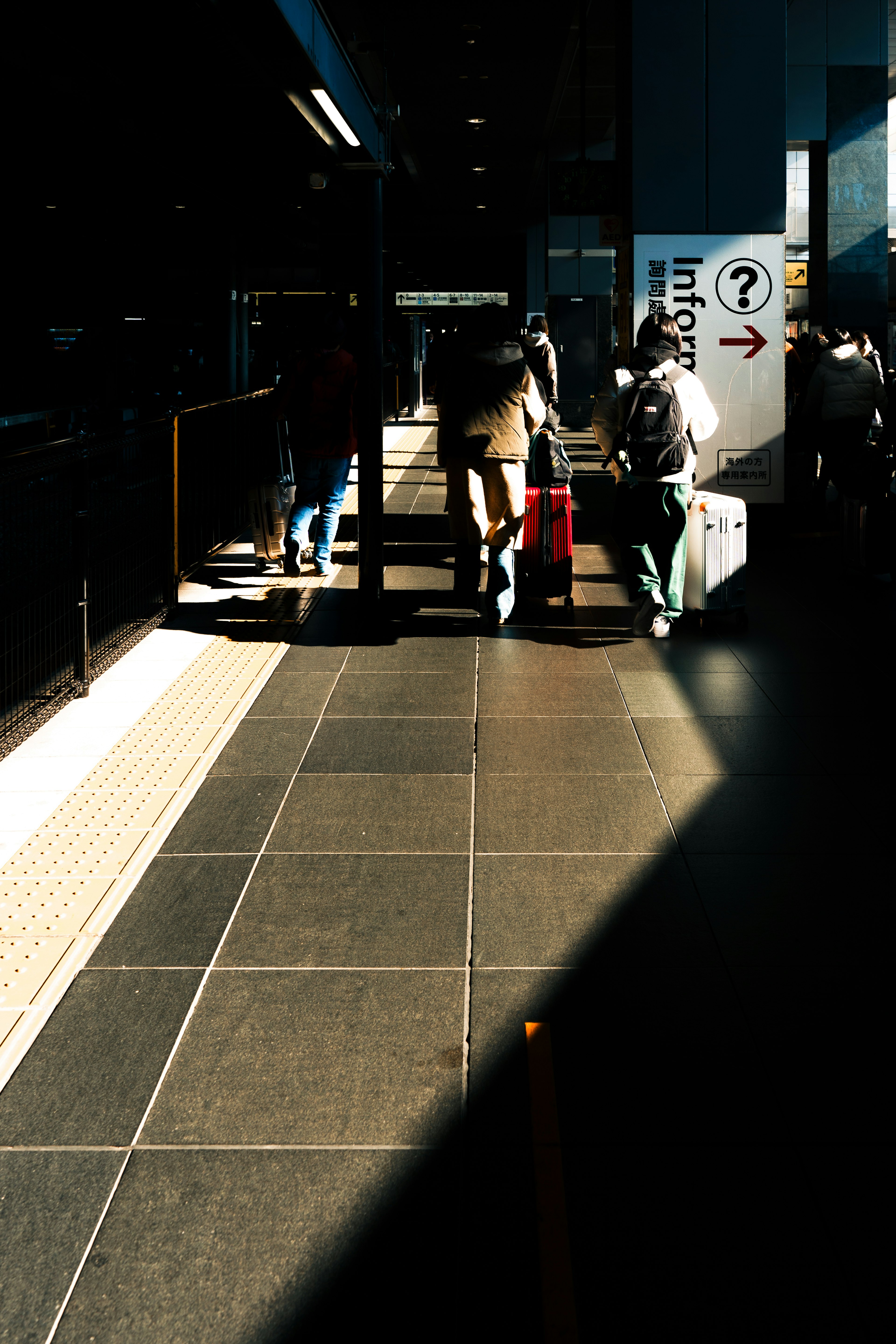 駅のプラットフォームで歩く人々と荷物