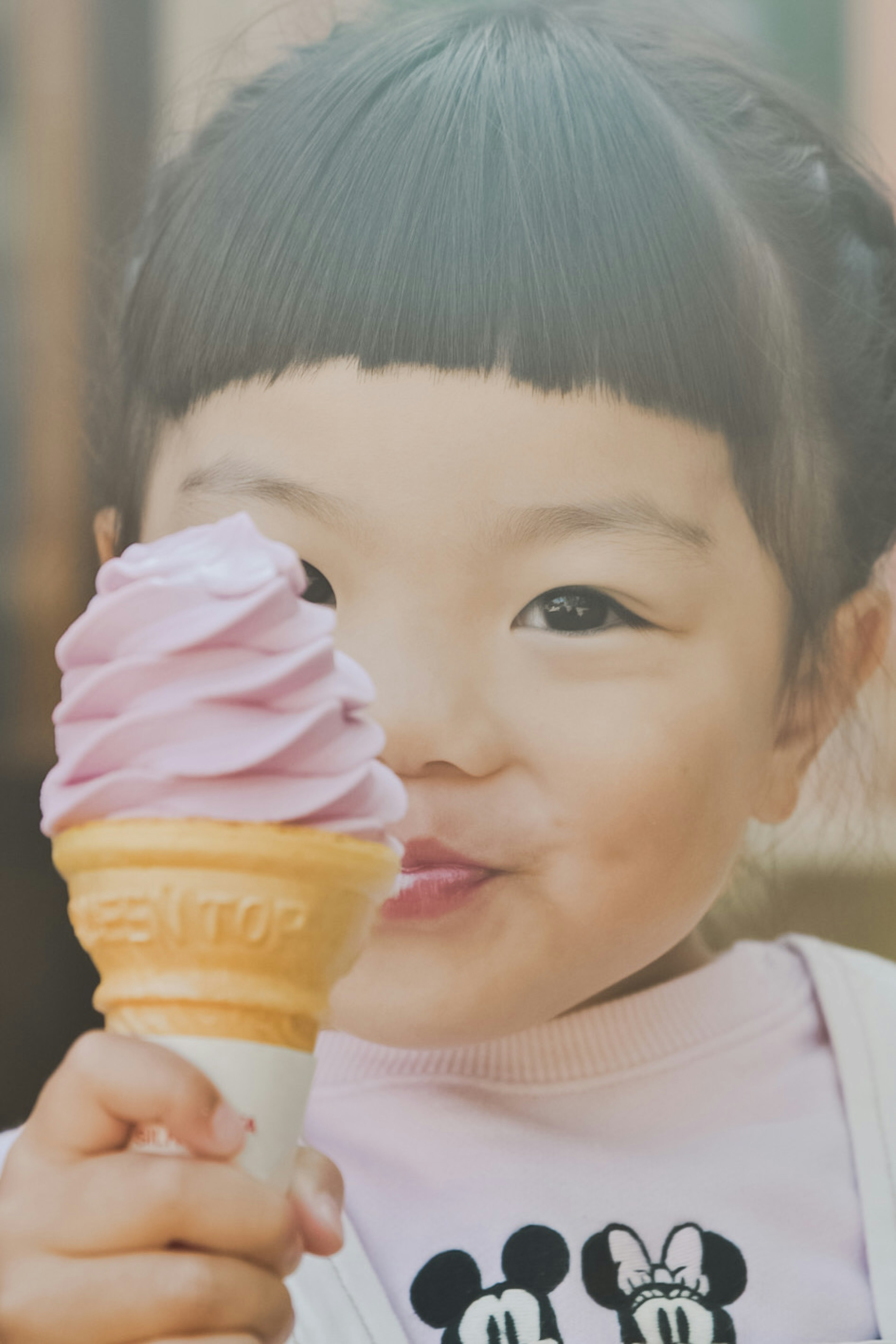 Un niño sonriente sosteniendo un cono de helado morado