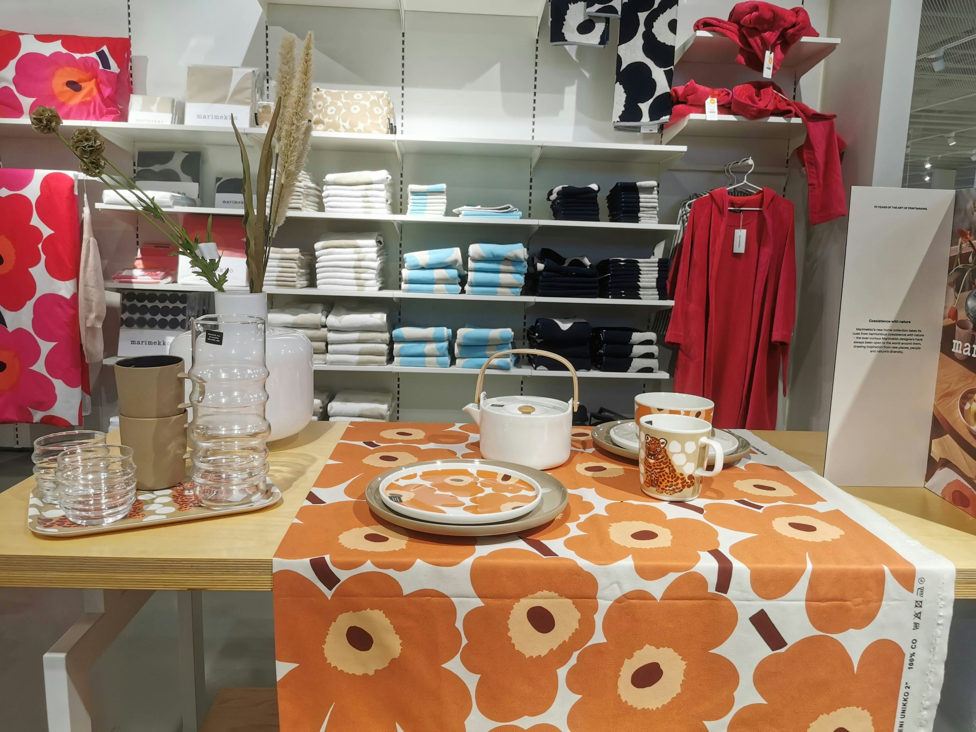 Interior scene with orange floral tablecloth featuring dishes and decorative items