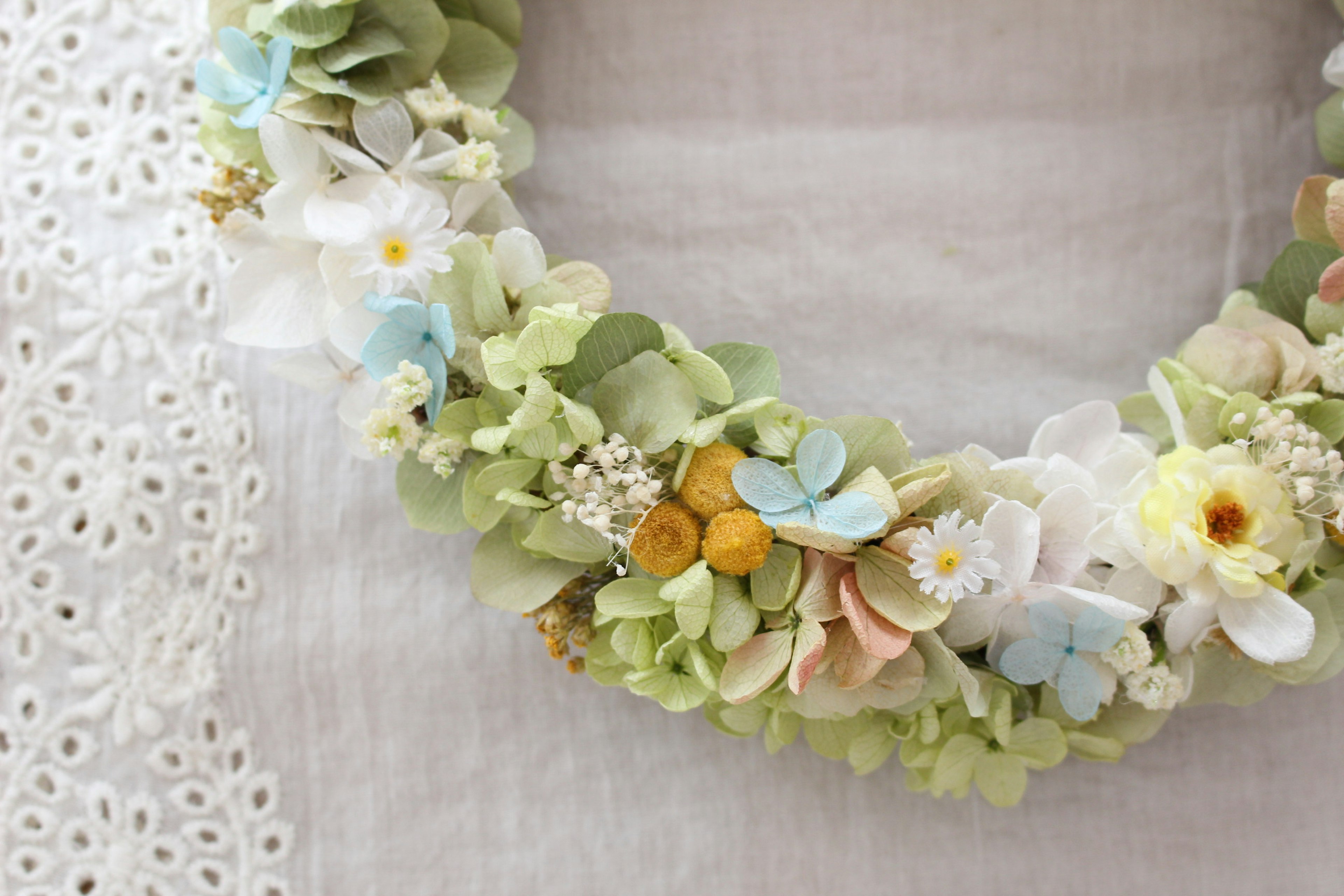 Close-up of a floral wreath adorned with soft-colored flowers and green leaves